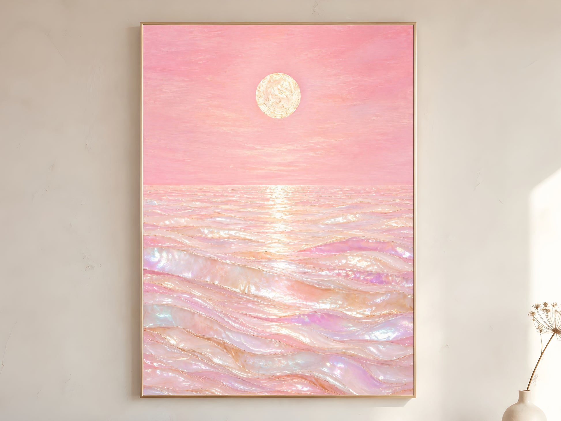 Pink capiz shell ocean wall art in gold frame on neutral wall beside dried flowers
