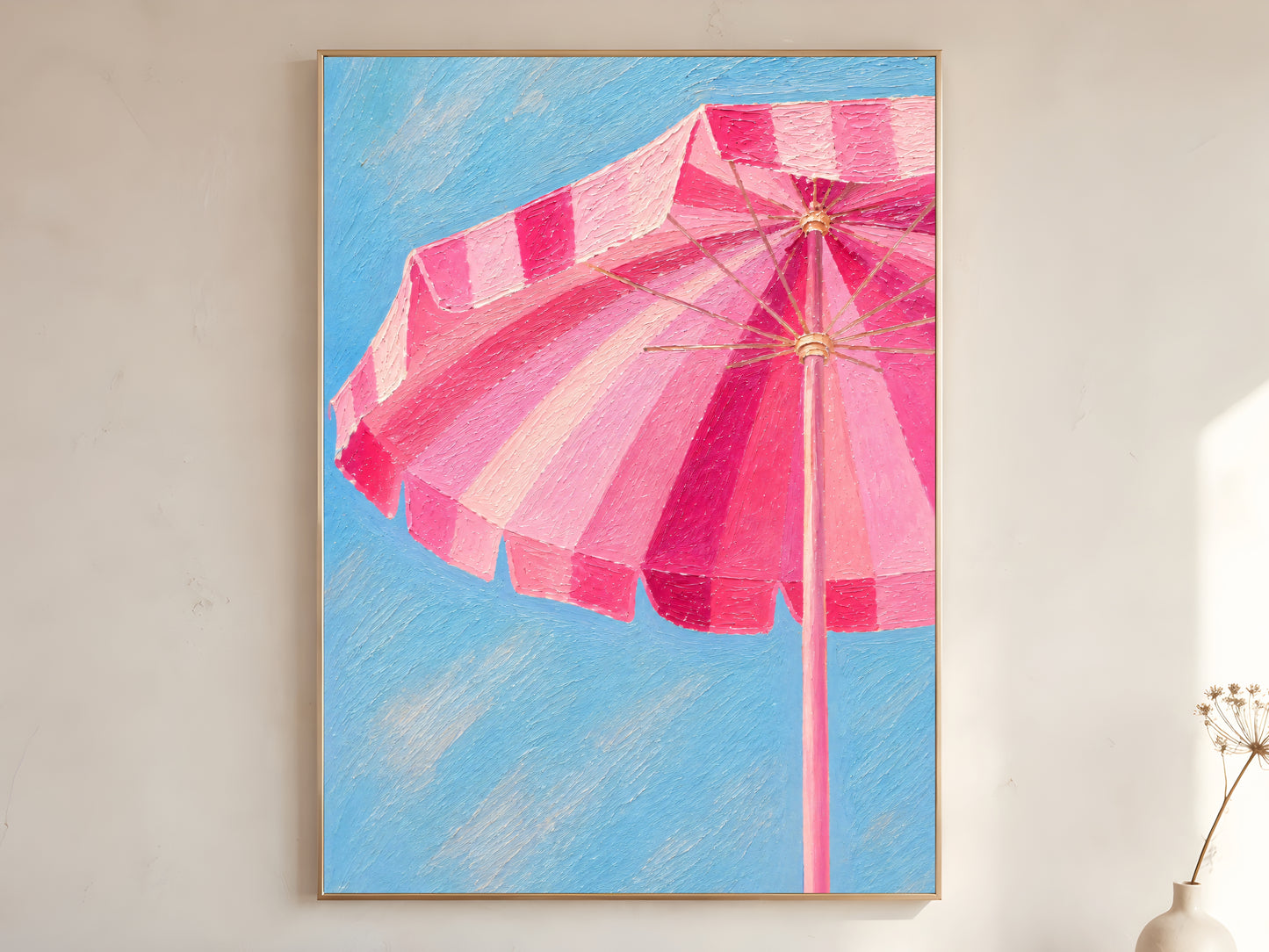 Pink beach umbrella wall art printable featuring a striped pink cabana umbrella against a bright blue sky displayed in a warm neutral interior.