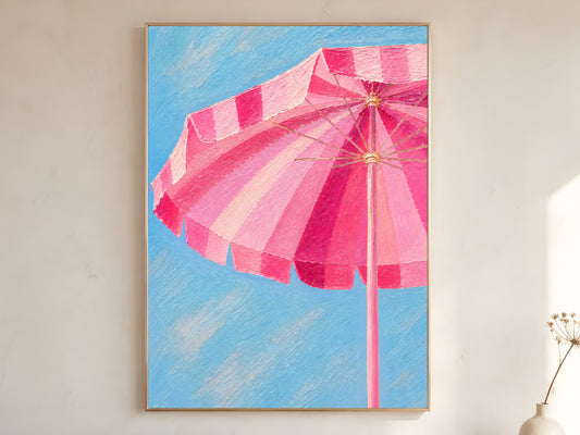 Pink beach umbrella wall art printable featuring a striped pink cabana umbrella against a bright blue sky displayed in a warm neutral interior.