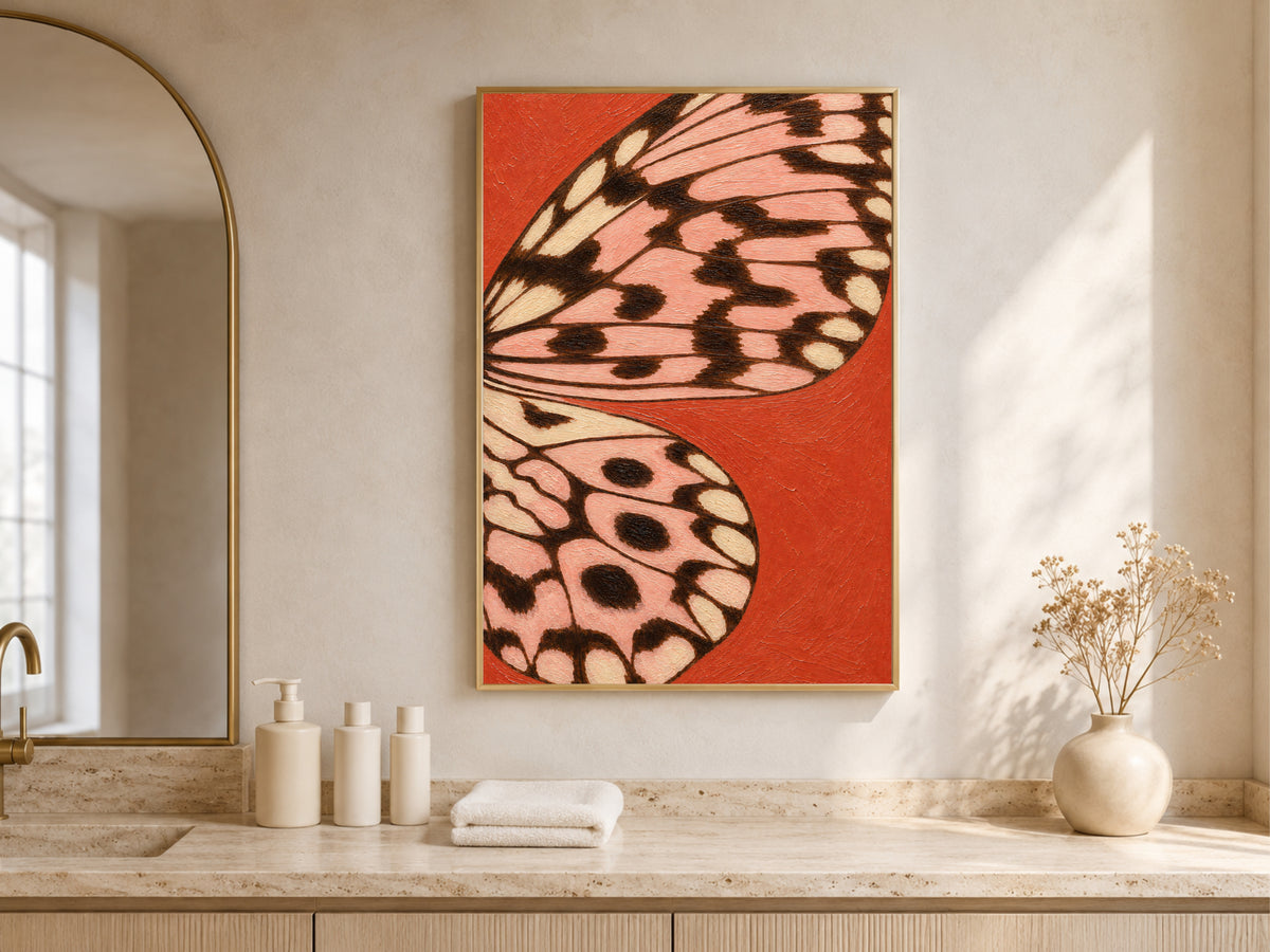 Tomato red butterfly wing print framed above a bathroom counter with toiletries and a vase