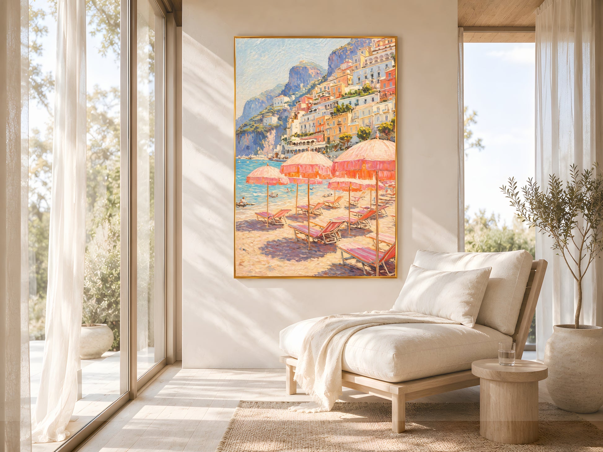 Positano beach club impasto wall art print in gold frame on warm white wall in bright Mediterranean living room with floor-to-ceiling windows, linen daybed and olive tree