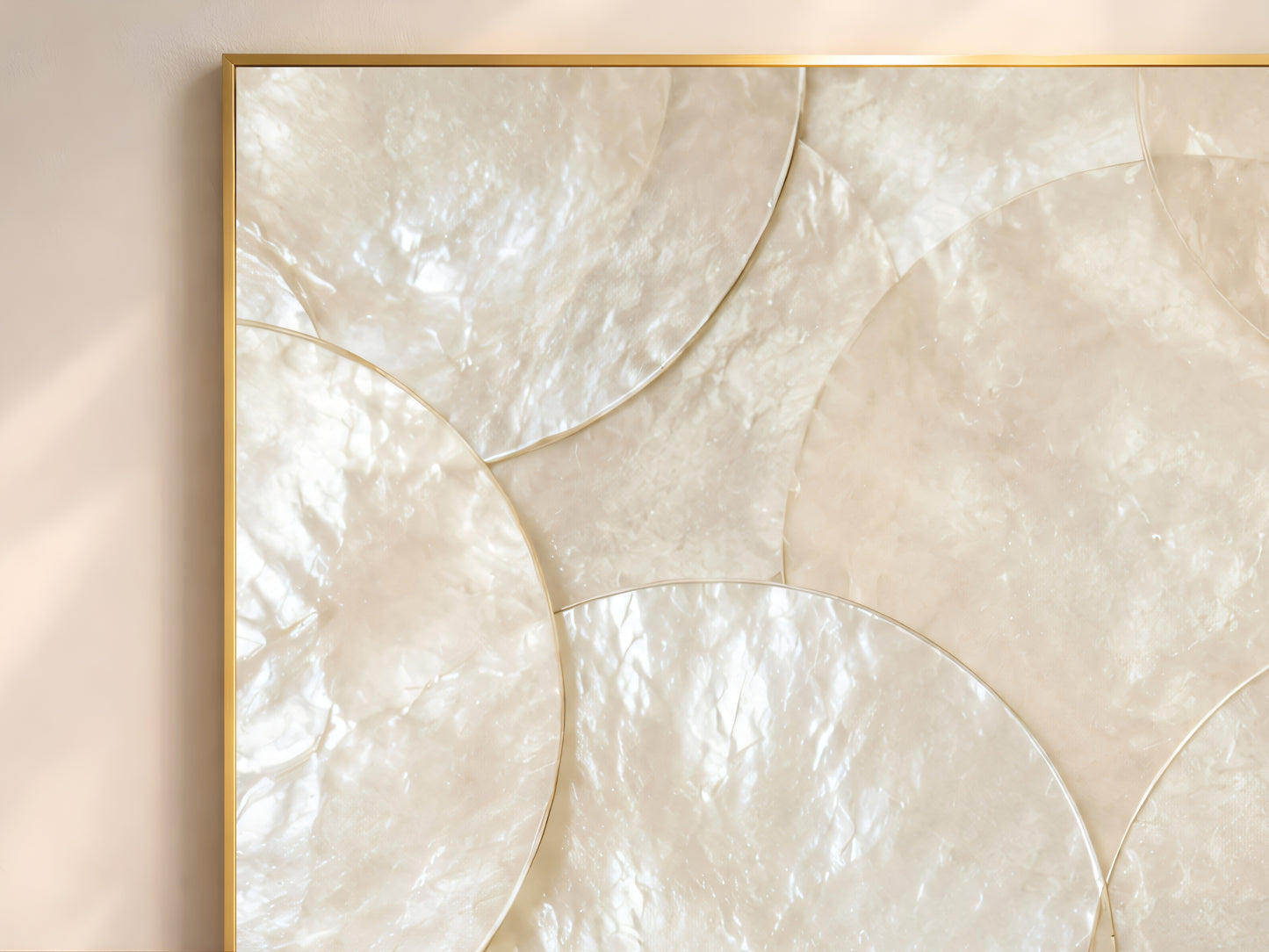 Close-up of large capiz shell wall art print showing oversized overlapping ivory and pearlescent white shell discs catching warm natural light
