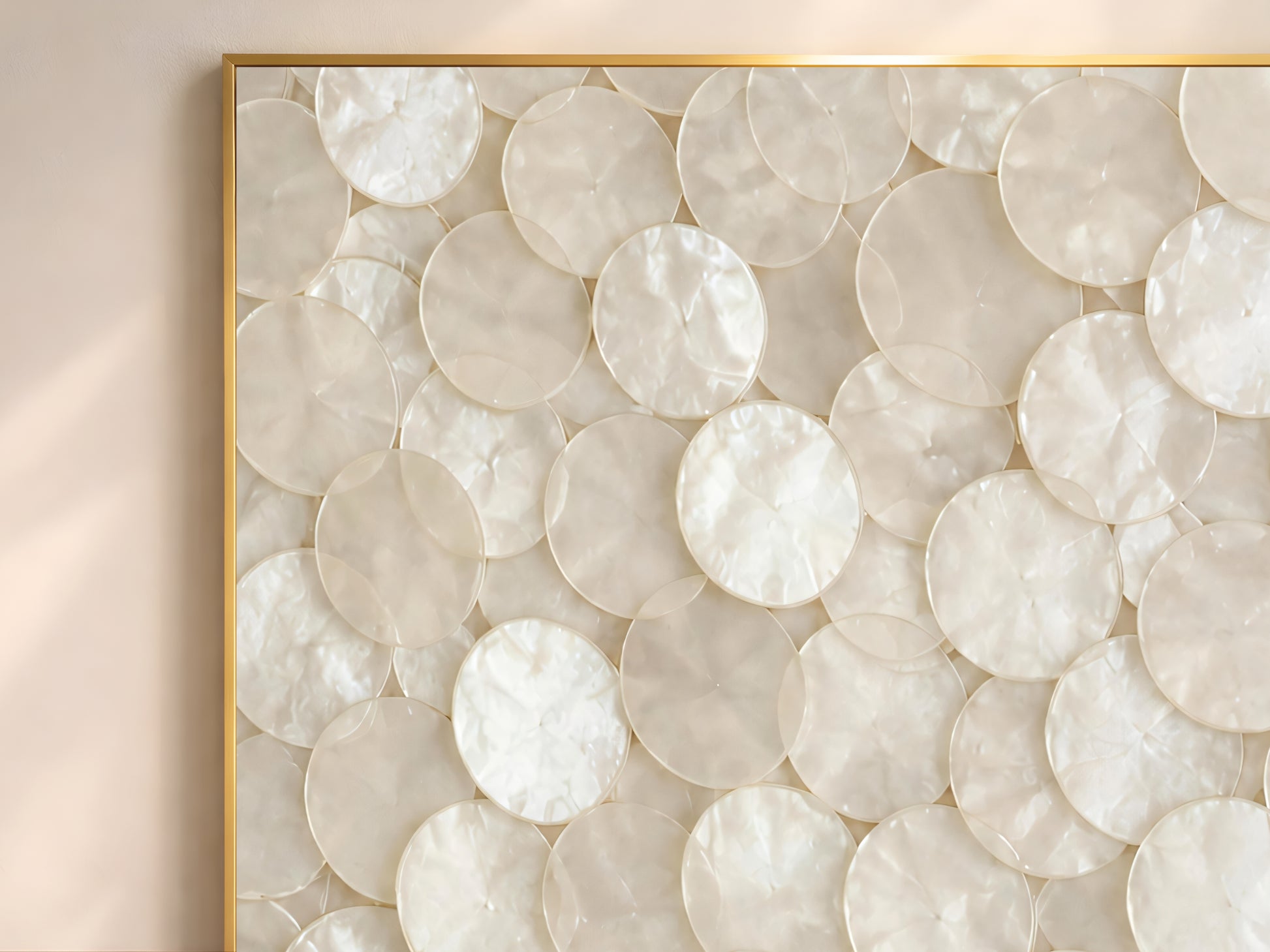 Close-up of capiz shell wall art print showing overlapping pearlescent ivory and warm white shell discs catching soft natural light
