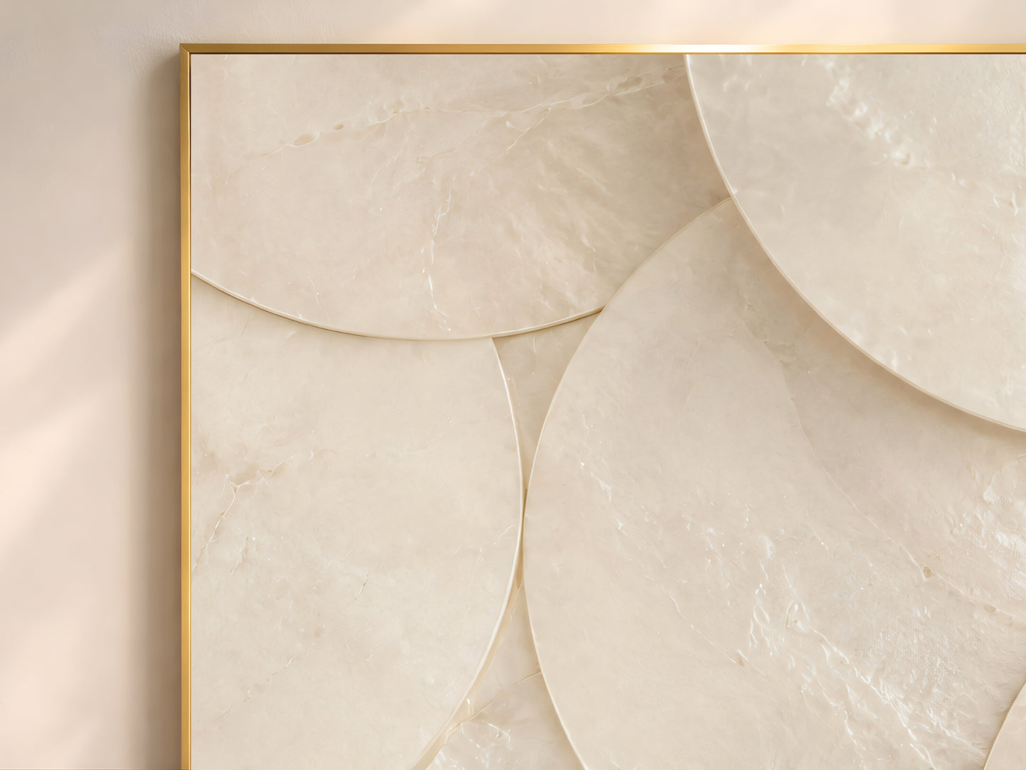 Close-up of minimalist capiz shell disc wall art in gold frame showing large overlapping chalk white and warm ivory shell circles on warm neutral wall
