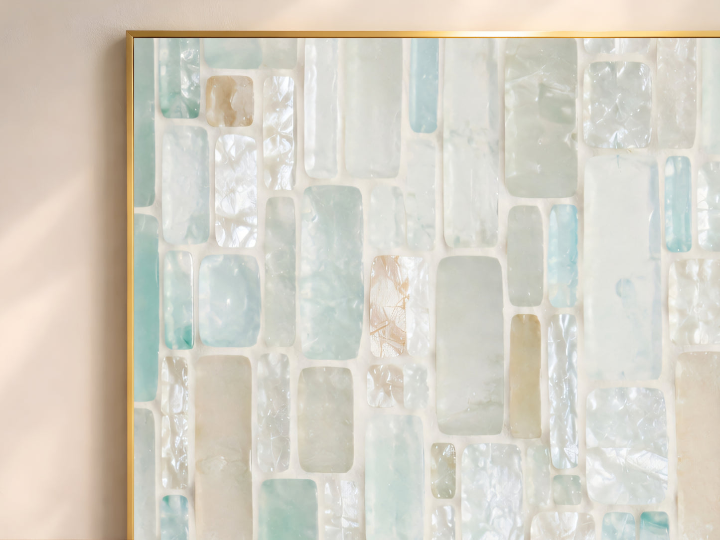 Close-up of sea glass mosaic tile wall art in gold frame showing translucent aqua seafoam teal pearl white and warm sand rectangular tile pieces with iridescent texture
