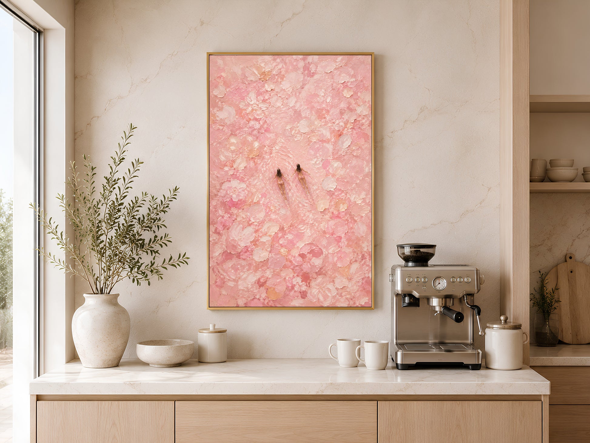 Pink swimmers wall art in a gold frame displayed in a warm living room with dried botanicals, a coffee machine, and light wood furniture
