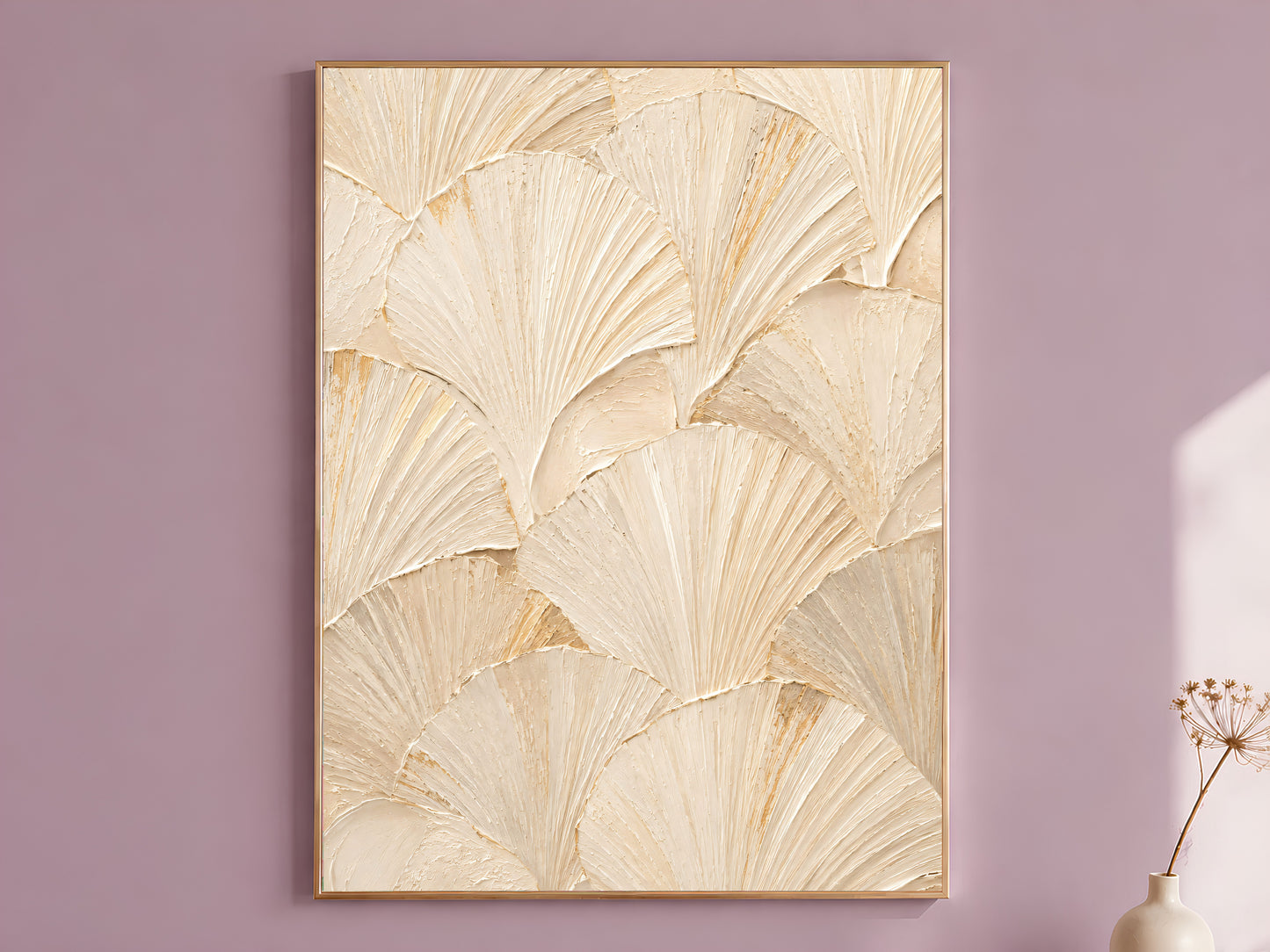 Ginkgo leaf wall art in a gold frame on a mauve wall, styled with a dried flower stem in a vase.
