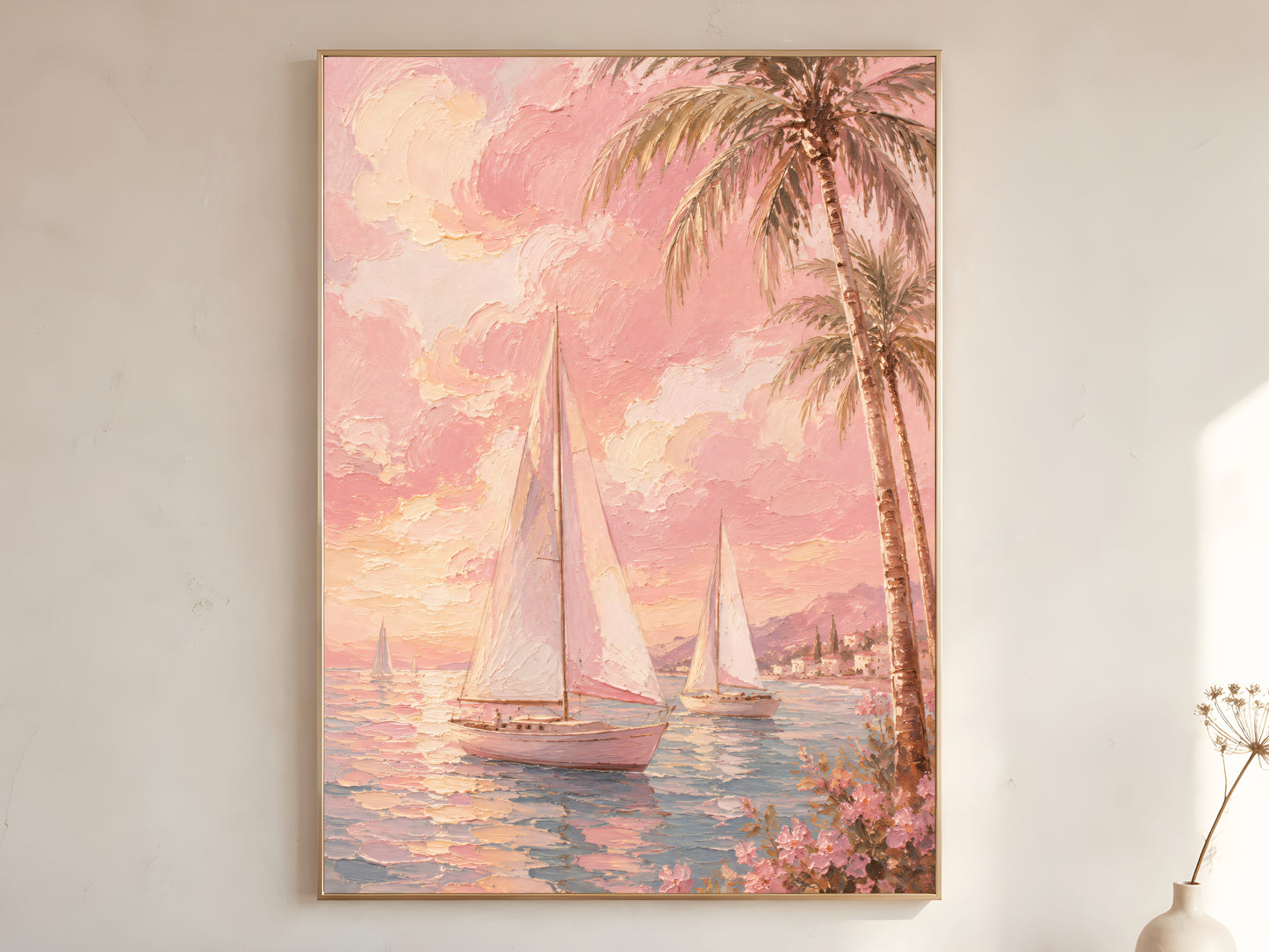 Pink sailboat oil painting in gold frame leaning against a white wall with dried florals