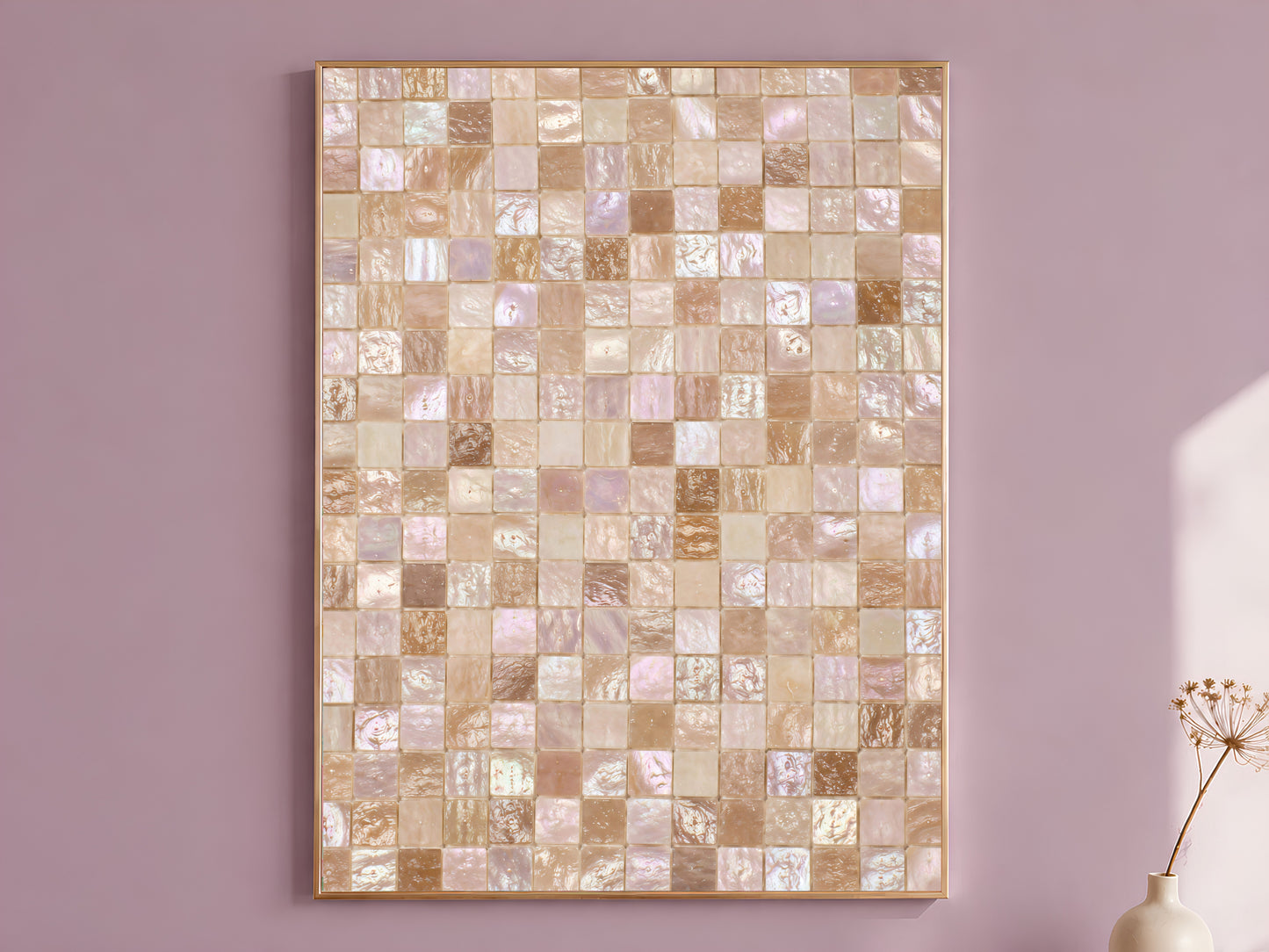 Mother of pearl mosaic wall art print in a gold frame hanging on a dusty mauve wall beside a vase of dried flowers.