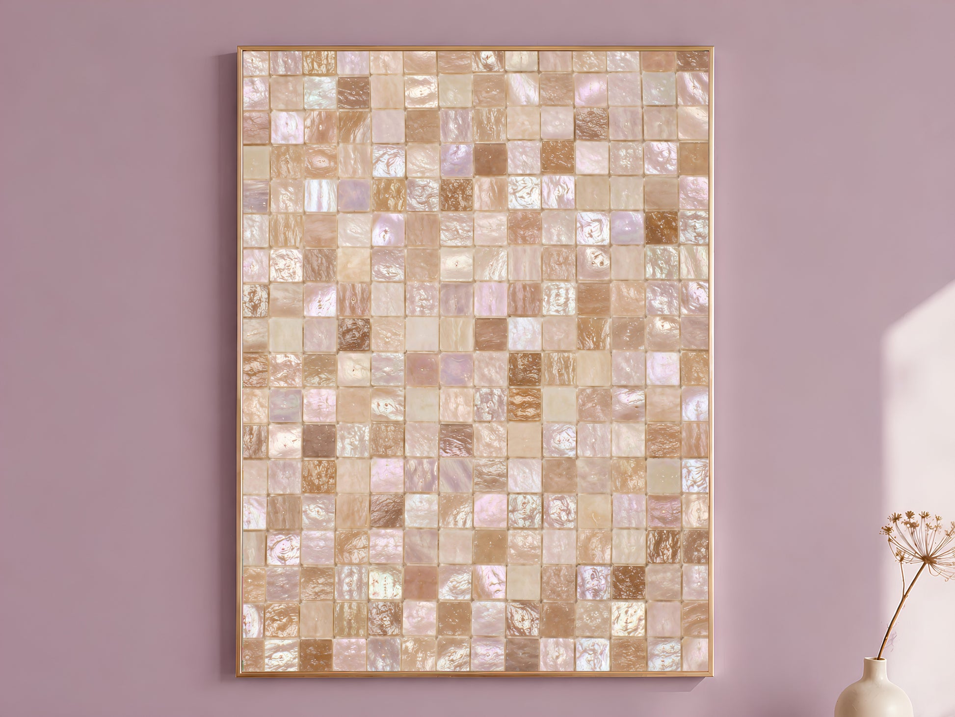 Mother of pearl mosaic wall art print in a gold frame hanging on a dusty mauve wall beside a vase of dried flowers.