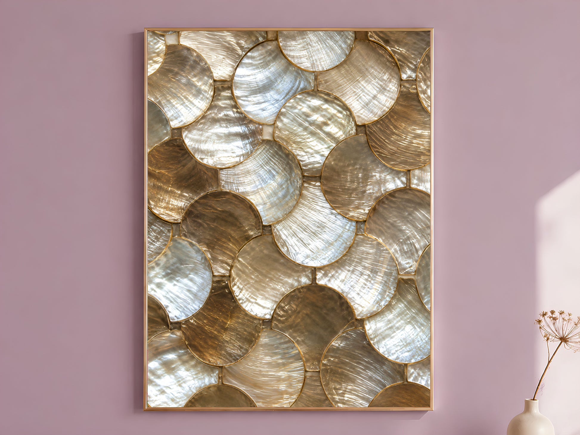 Gold abstract wall art print in a thin gold frame hanging on a dusty mauve wall beside a vase of dried flowers.
