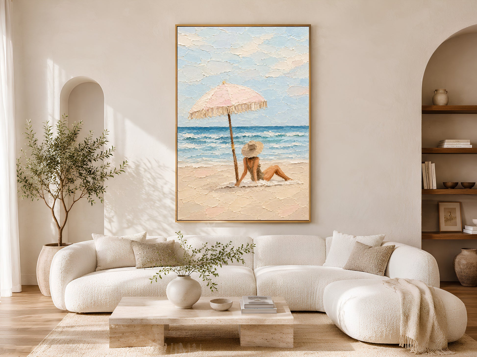 Framed beach scene impasto wall art displayed above a curved cream sofa in a bright boho living room with olive tree and arch detail
