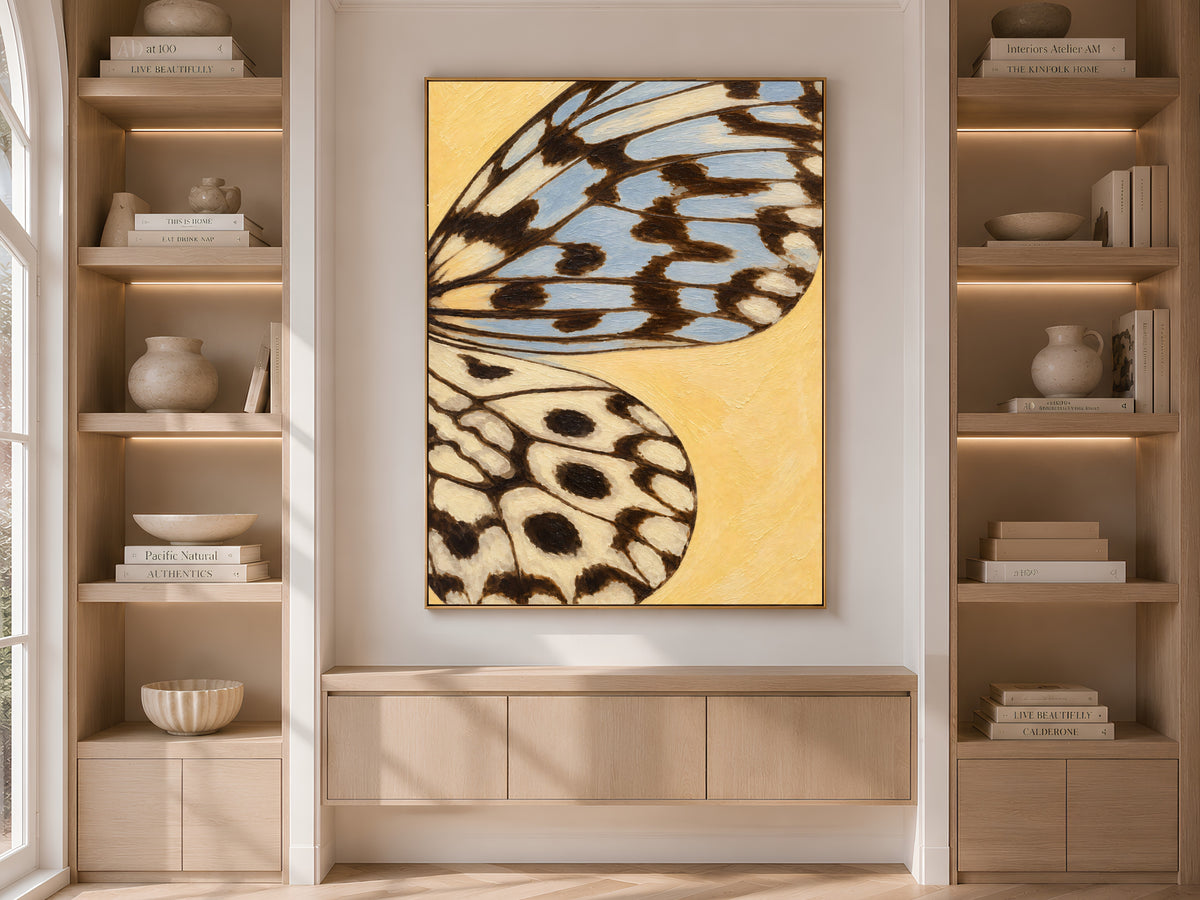 Butter yellow butterfly wing print framed on built-in shelving in a warm neutral living room