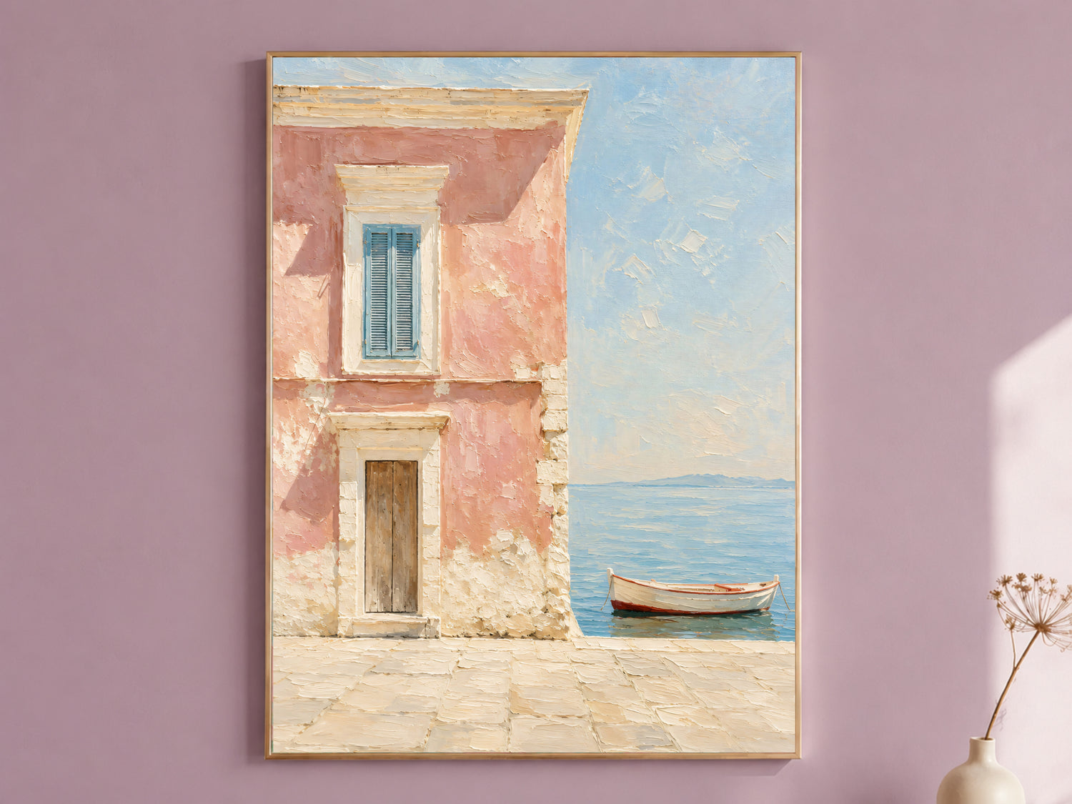 Pink Amalfi Coast wall art print in a thin gold frame, mounted on a dusty mauve wall, showing a Mediterranean pink house facade with blue shutters and a wooden boat