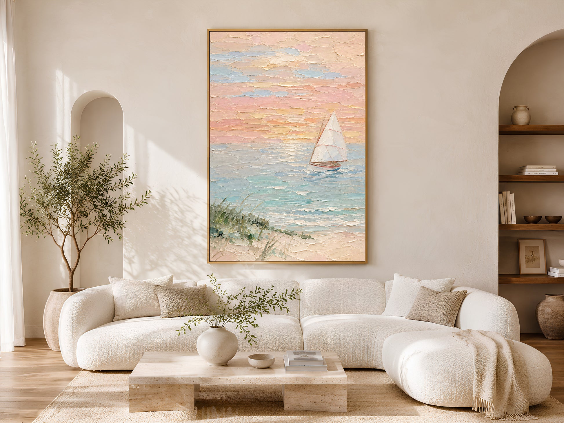 Framed sailboat sunset wall art displayed on wall in a bright Scandinavian living room with curved cream sofa, arch doorway, and olive tree
