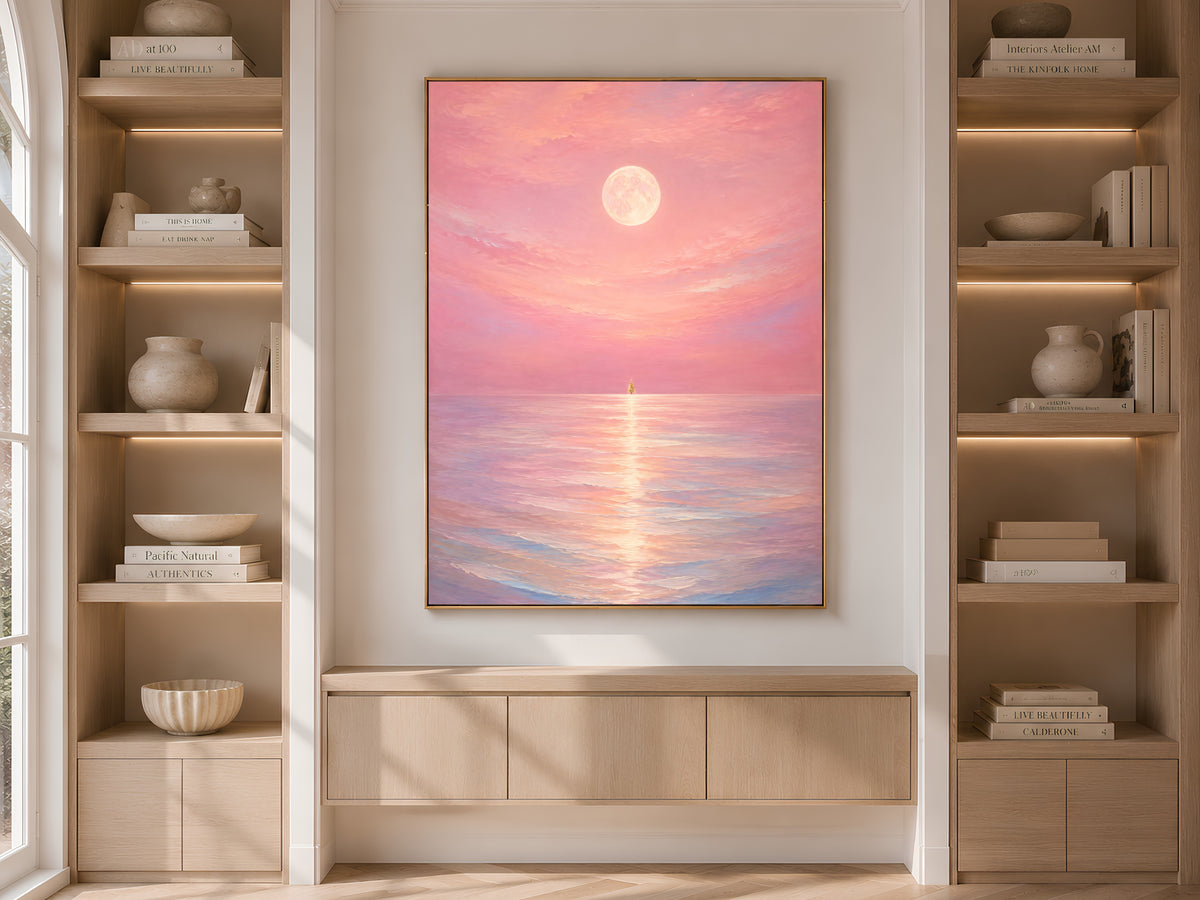 Pink moon ocean print framed and displayed in built-in wood shelving with books and decor