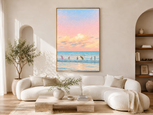 Framed impasto pastel sunset surf print on warm white wall in minimal living room with curved cream sofa and arch window
