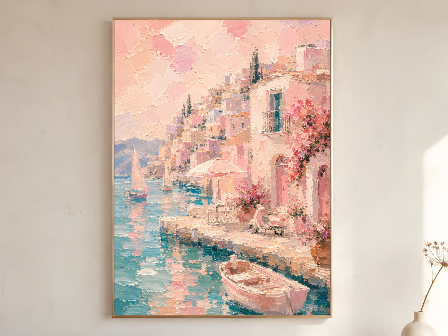 Pink Mediterranean village oil painting in gold frame leaning against a white wall with dried florals