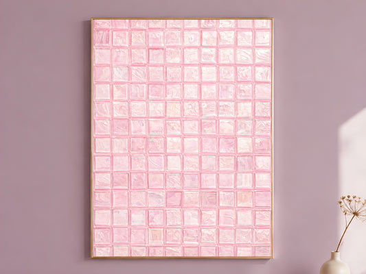 Blush pink impasto mosaic tile wall art in a thin gold frame leaning against a dusty mauve wall with a dried allium stem in a cream vase beside it
