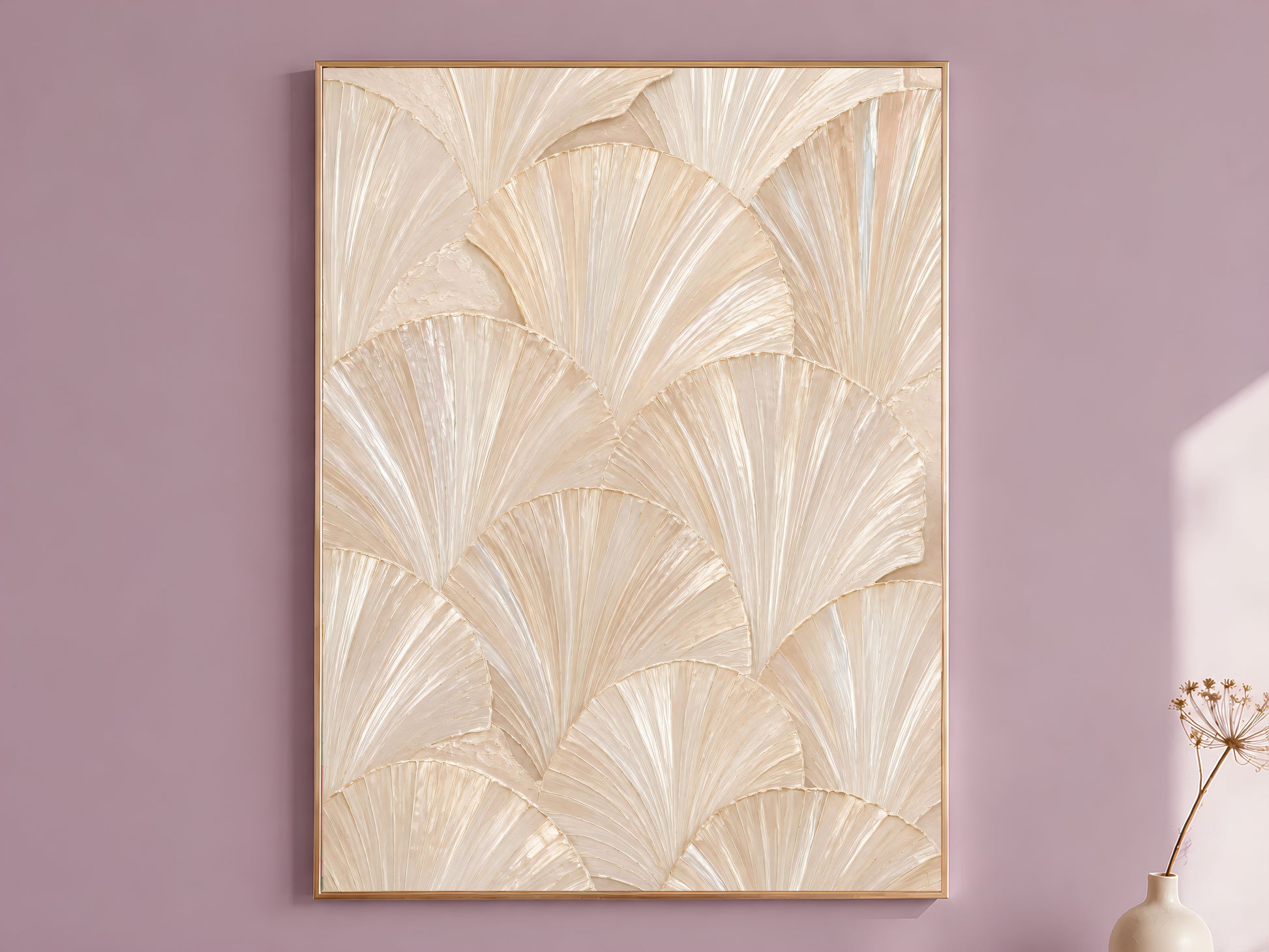 Ivory capiz shell wall art in a thin gold frame, hung on a dusty mauve wall with a small dried flower stem beside it.