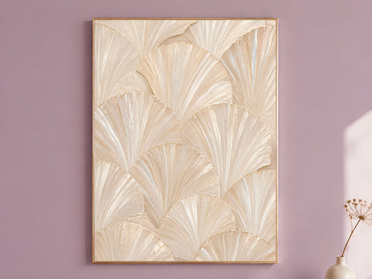 Ivory capiz shell wall art in a thin gold frame, hung on a dusty mauve wall with a small dried flower stem beside it.
