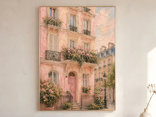 Pink Paris Haussmann building impasto wall art print with climbing roses and wrought iron balconies in a gold frame leaning against a warm white wall with dried stems

