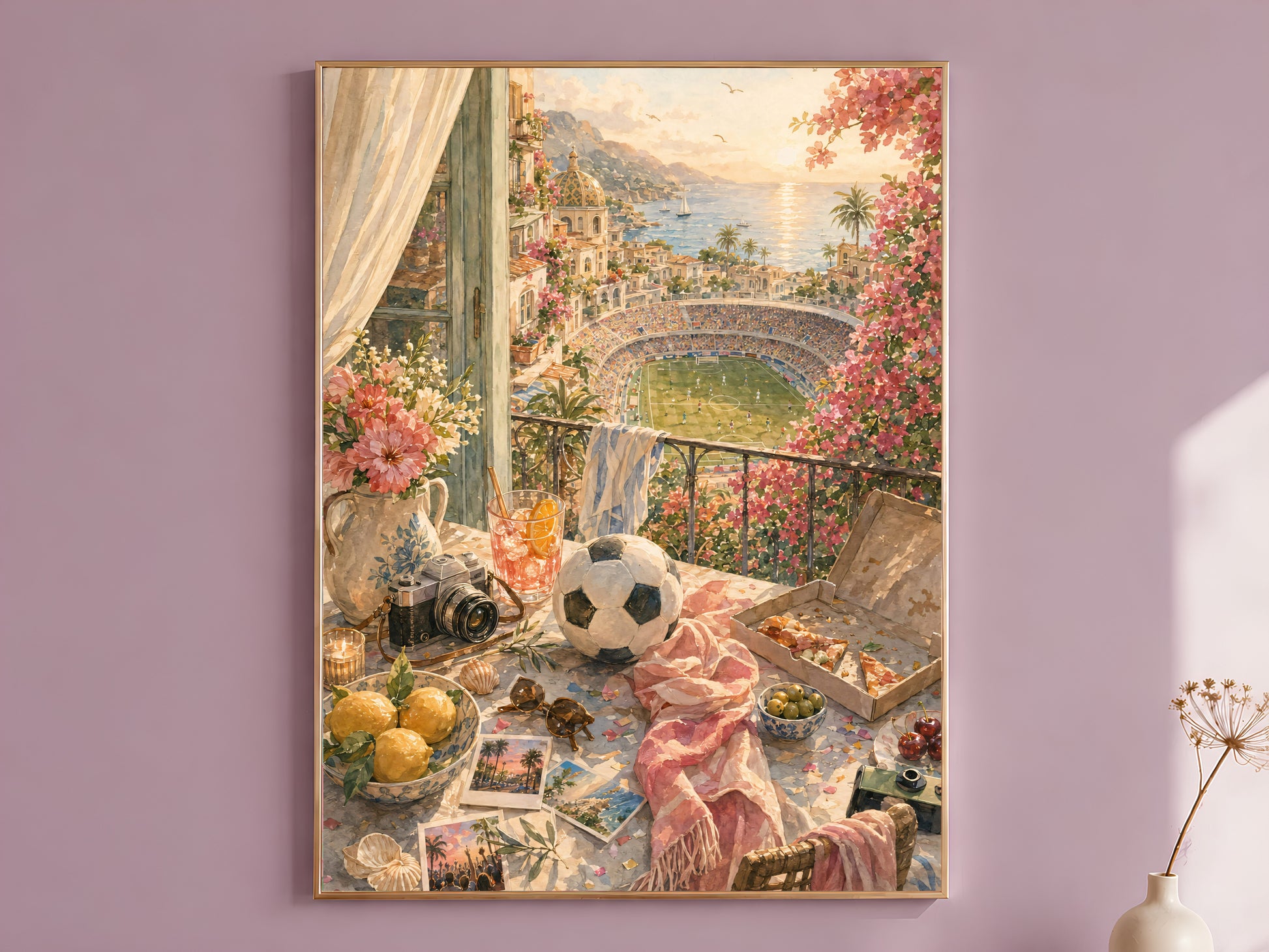 Framed sunset balcony wall art print in a thin gold frame, hanging on a dusty mauve wall beside a curtain and dried flower stem.
