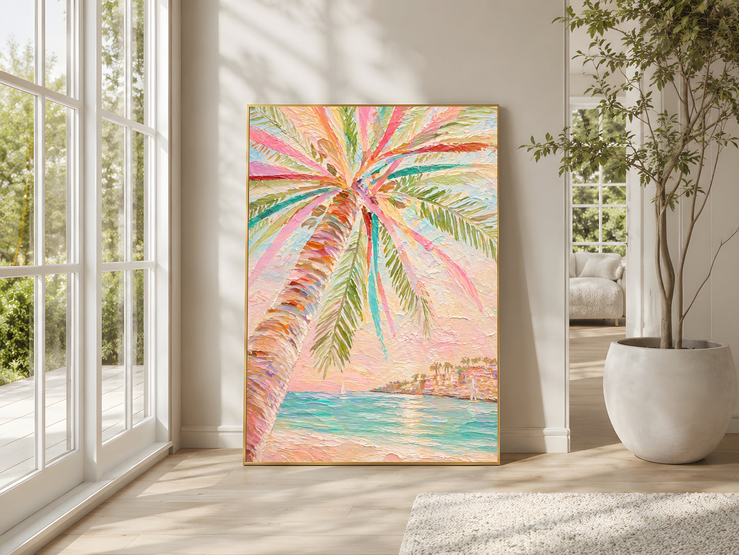 Large colorful palm tree impasto wall art in gold frame leaning against warm white wall in bright living room with floor-to-ceiling windows and indoor plant
