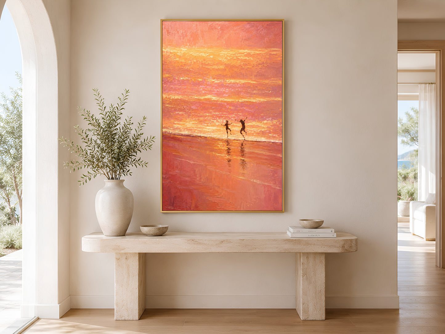 Pink sunset coastal wall art printable displayed above a beige console table in a bright Mediterranean hallway with soft natural light.