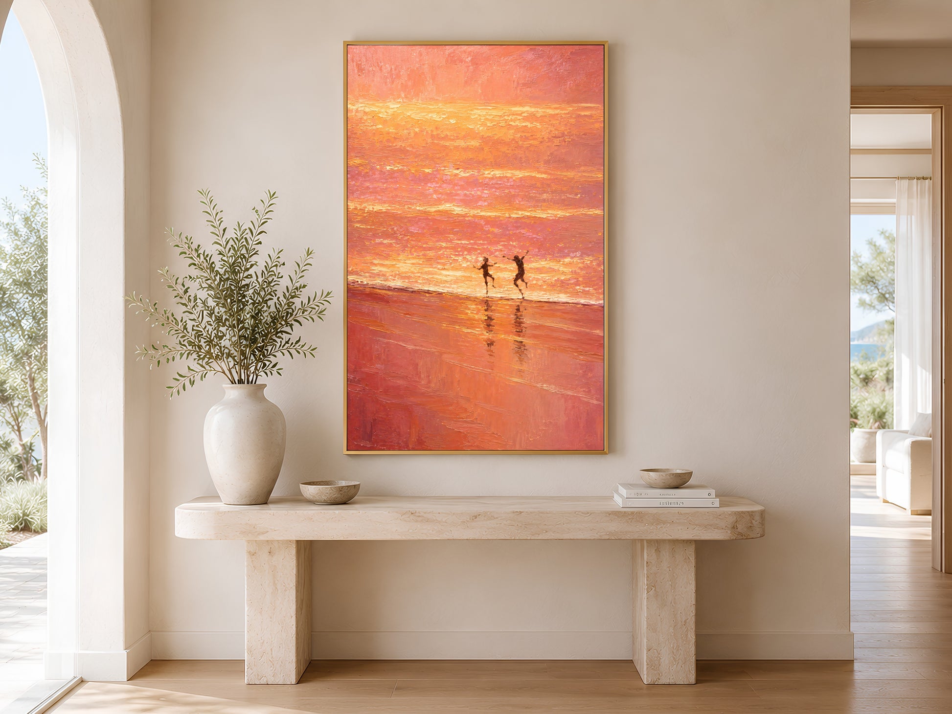 Pink sunset coastal wall art printable displayed above a beige console table in a bright Mediterranean hallway with soft natural light.