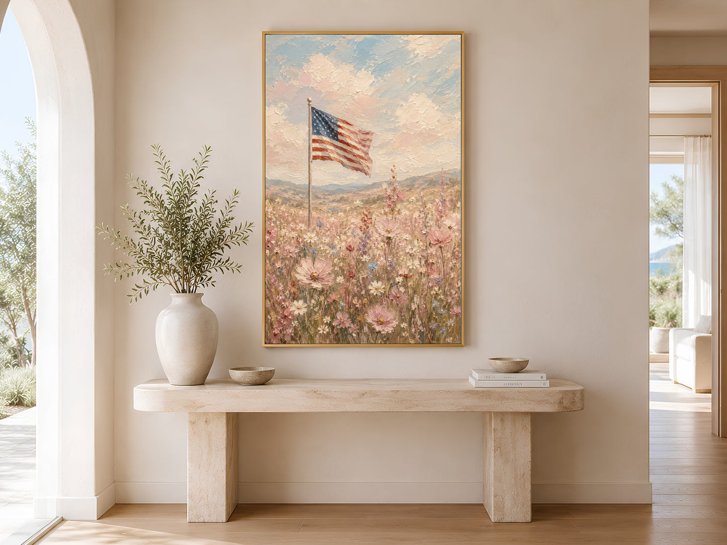 American flag wildflower field impasto painting in a gold frame displayed above a warm wood console table in a bright entryway with neutral vases and warm natural light

