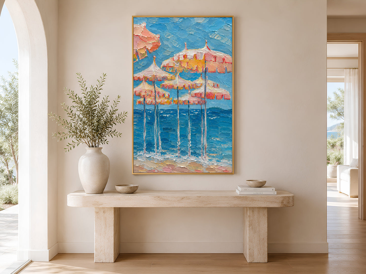 Pink parasol impasto coastal print in a gold frame above a minimalist console table with a small ceramic bowl in a neutral entryway
