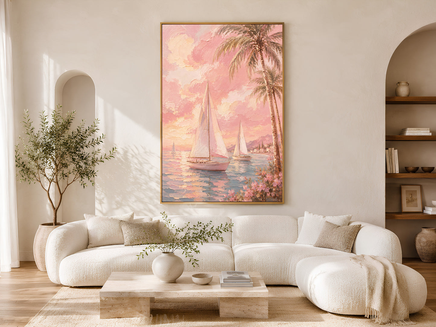 Tropical pink sailboat wall art in gold frame above a cream sofa in a bright neutral living room with arched shelving