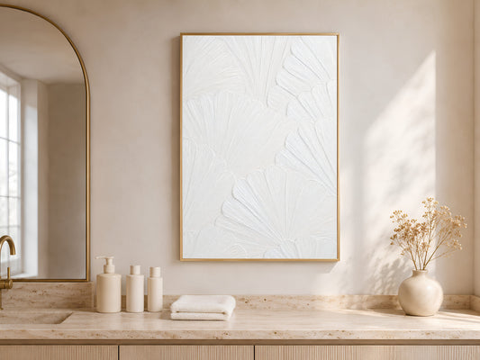 White textured plaster print displayed above a vanity in a neutral bathroom with fresh flowers
