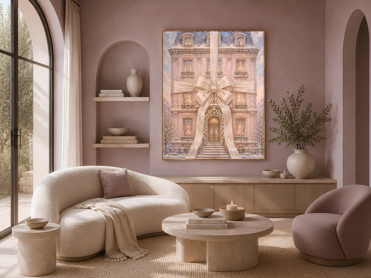 Pink chateau Christmas print framed on a wall beside a cream sofa and boucle chairs