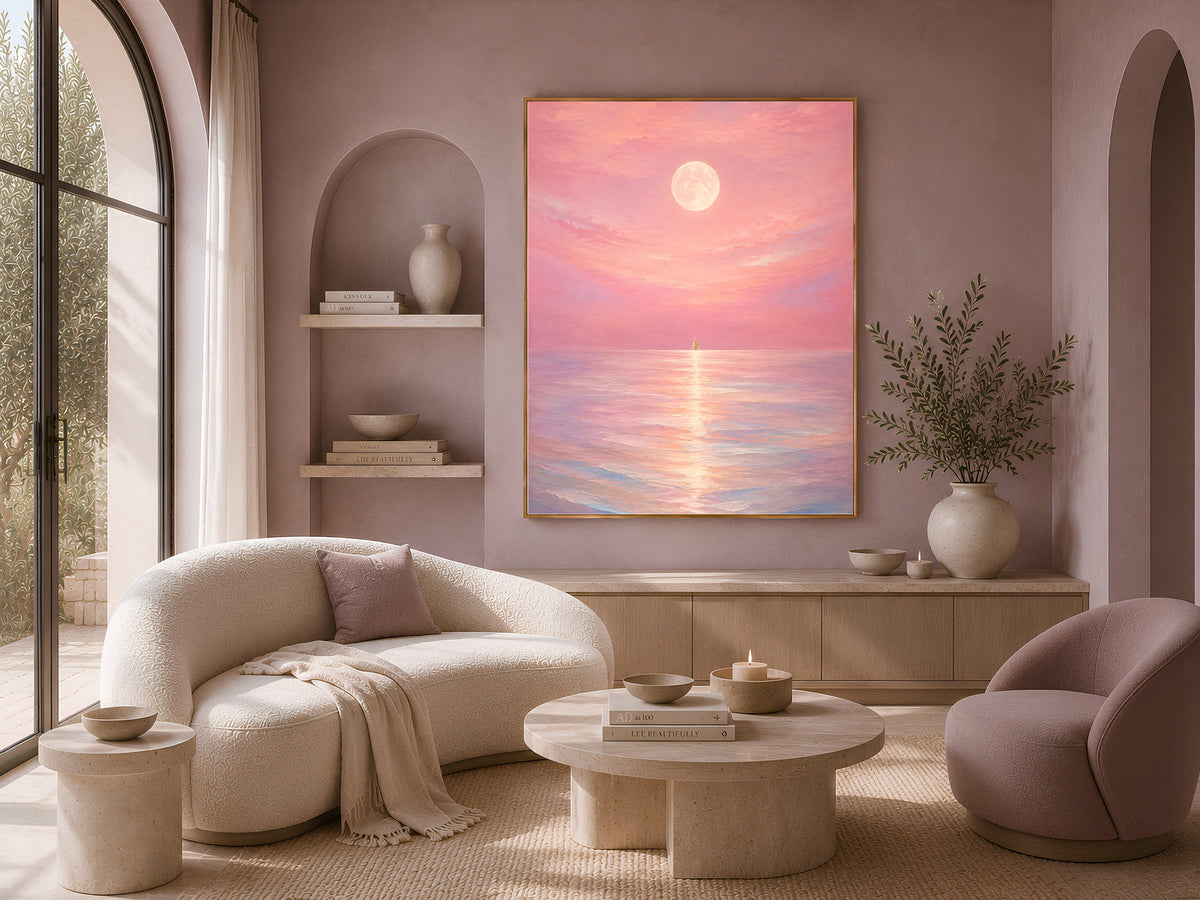 Pink moon ocean print framed on a wall beside a cream sofa and boucle armchair