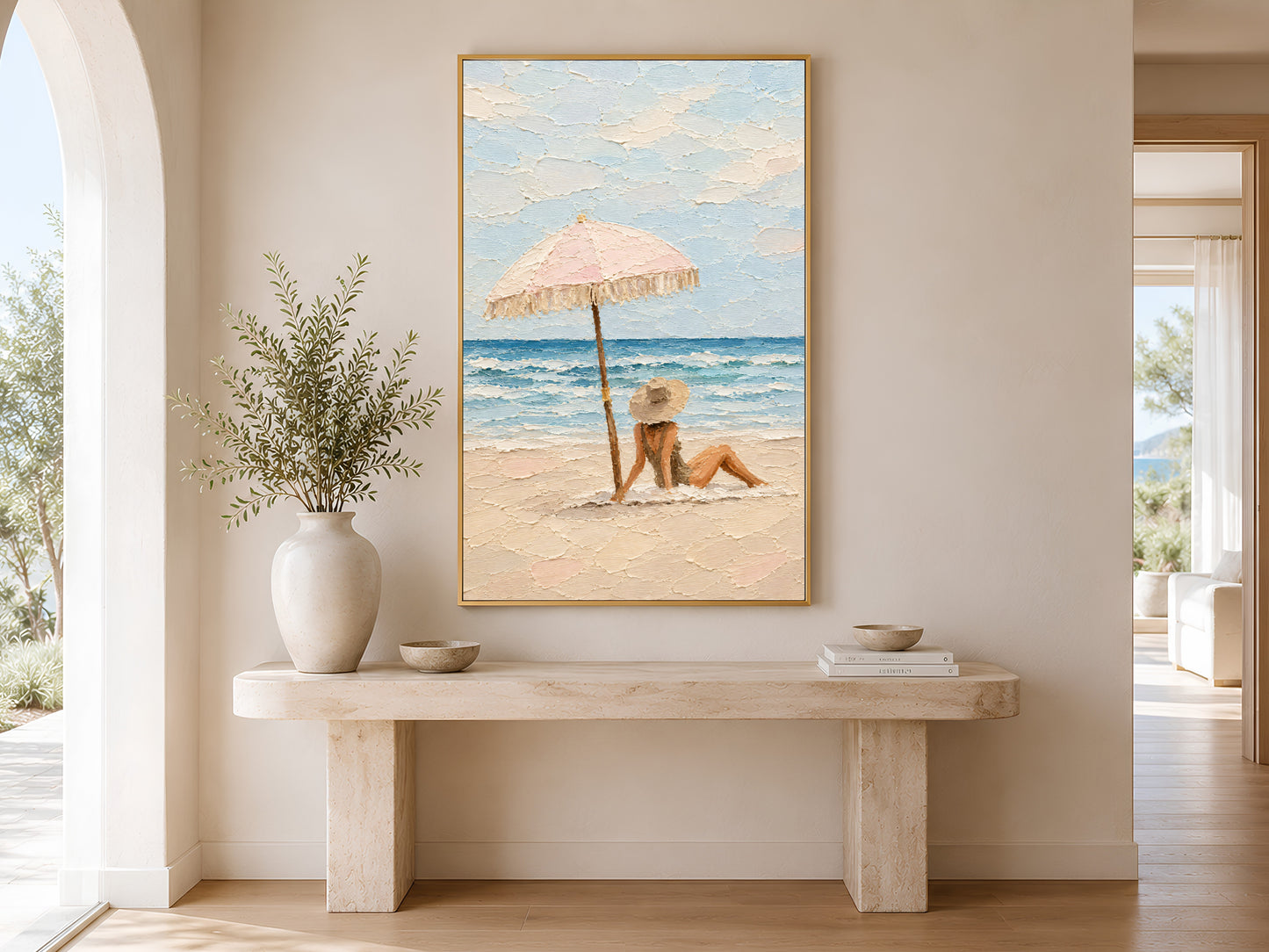 Framed beach scene impasto print displayed on wall in a bright entryway with wooden bench, linen cushion, and tall white ceramic vases
