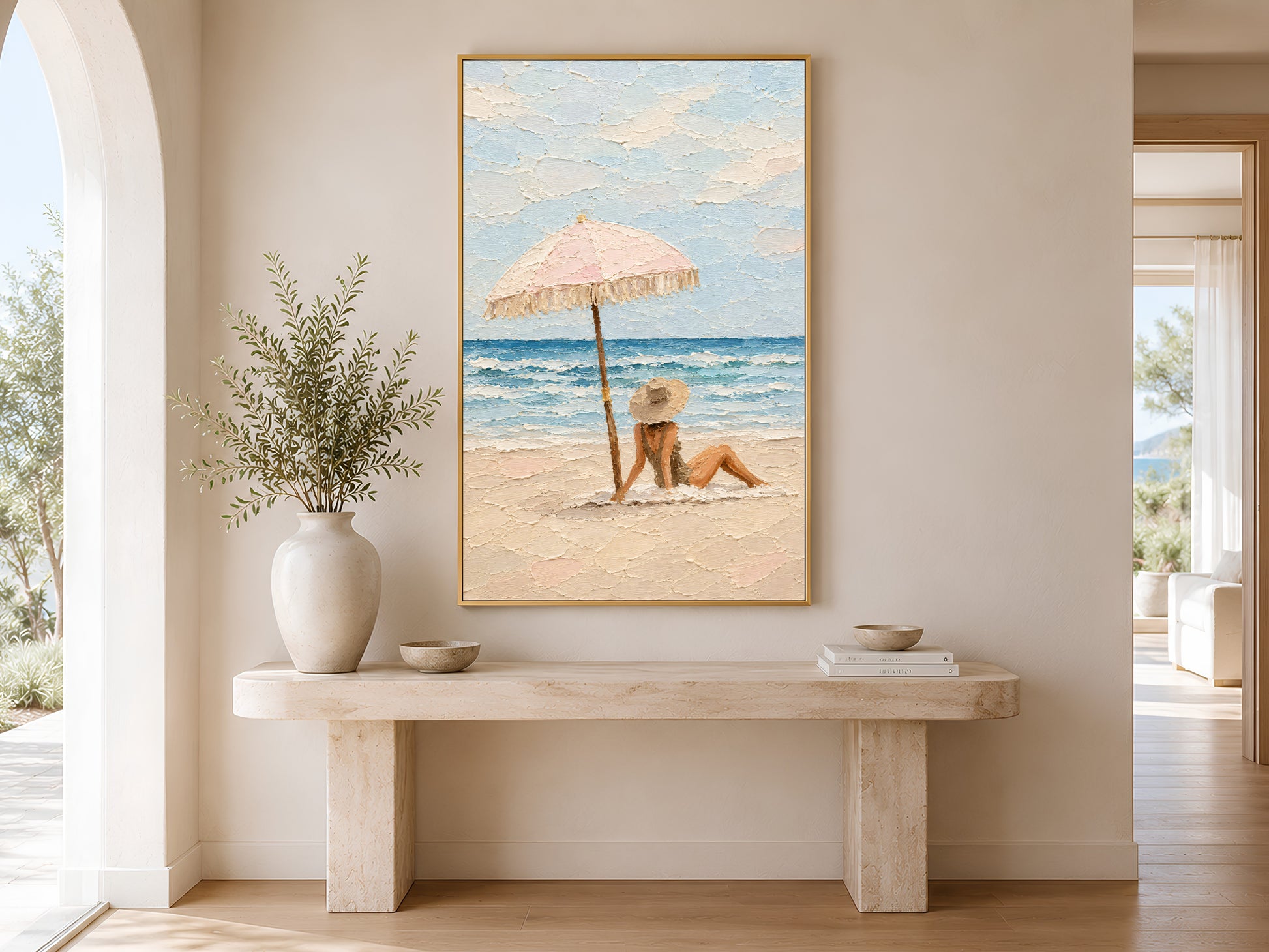 Framed beach scene impasto print displayed on wall in a bright entryway with wooden bench, linen cushion, and tall white ceramic vases
