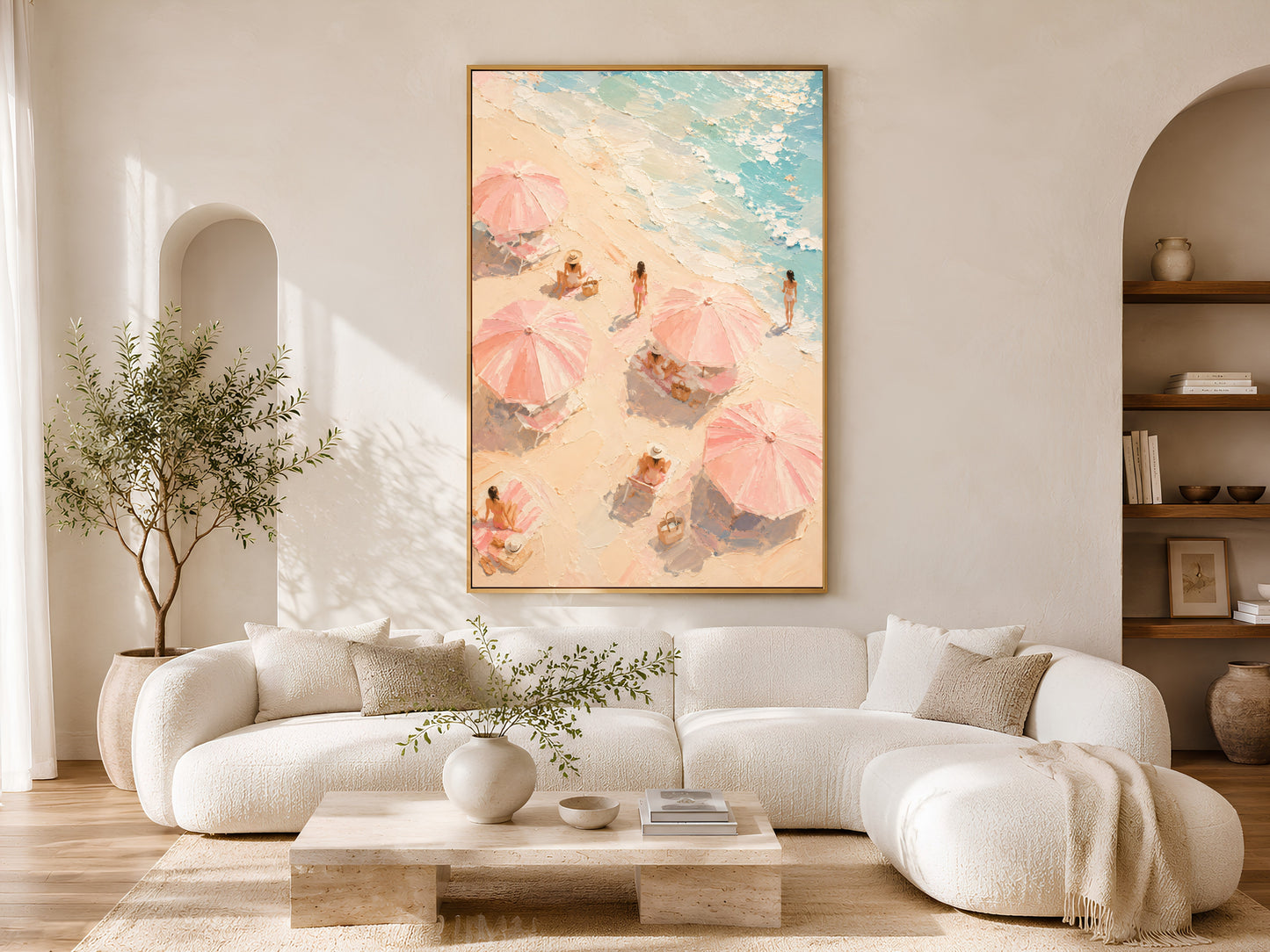 Aerial beach umbrella wall art in gold frame above a cream sofa in a bright neutral living room with arched shelving