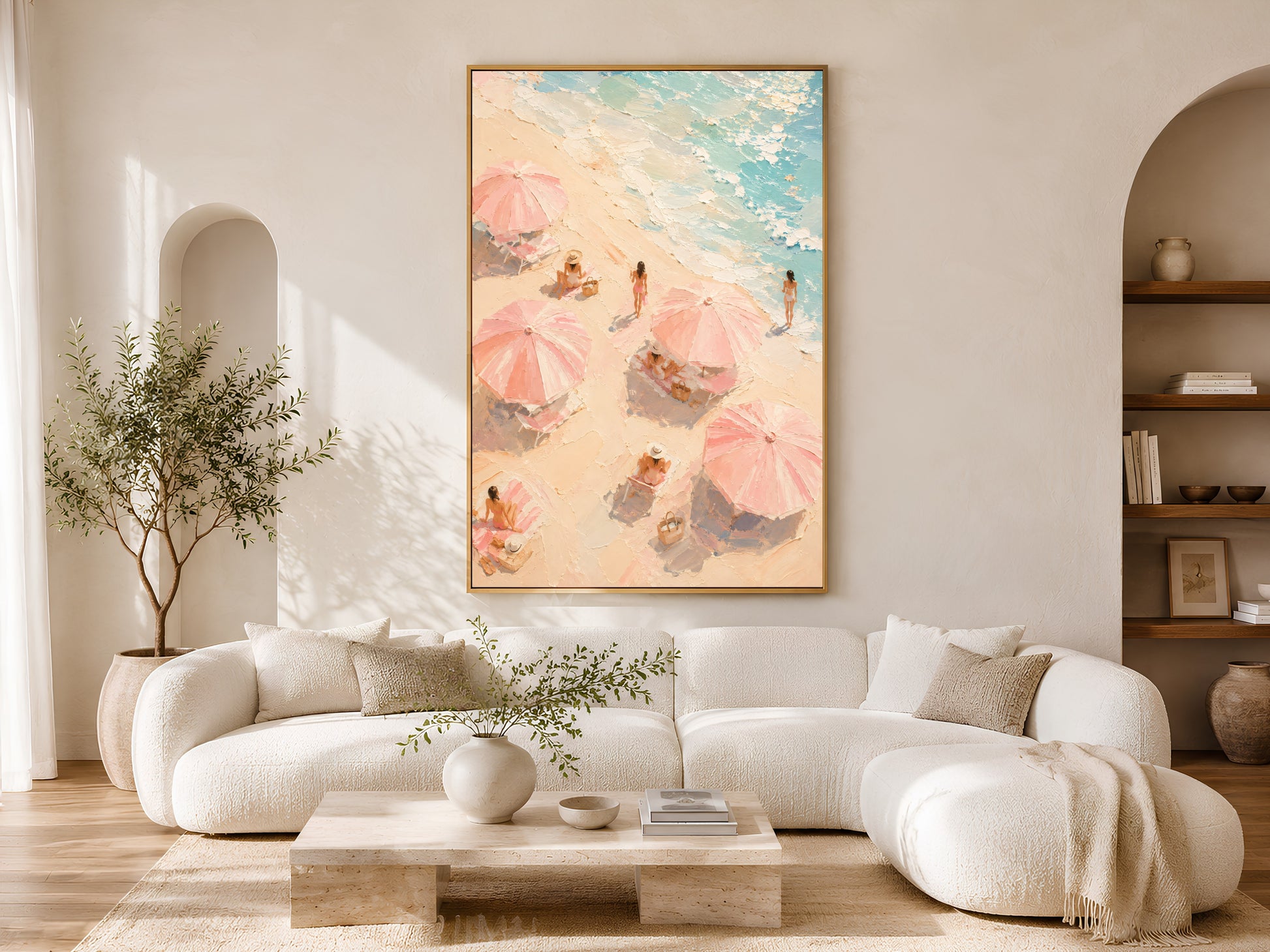 Aerial beach umbrella wall art in gold frame above a cream sofa in a bright neutral living room with arched shelving