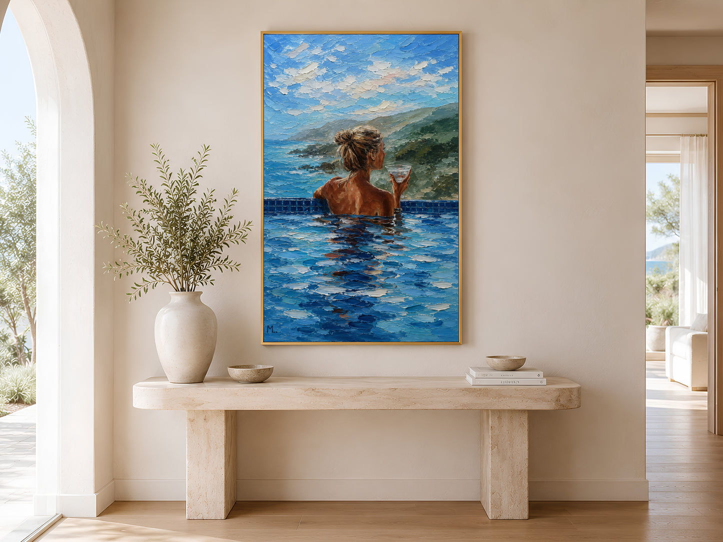 Gold-framed luxury pool view wall art above a minimalist console table with a round white vase and dried stems in a warm neutral entryway
