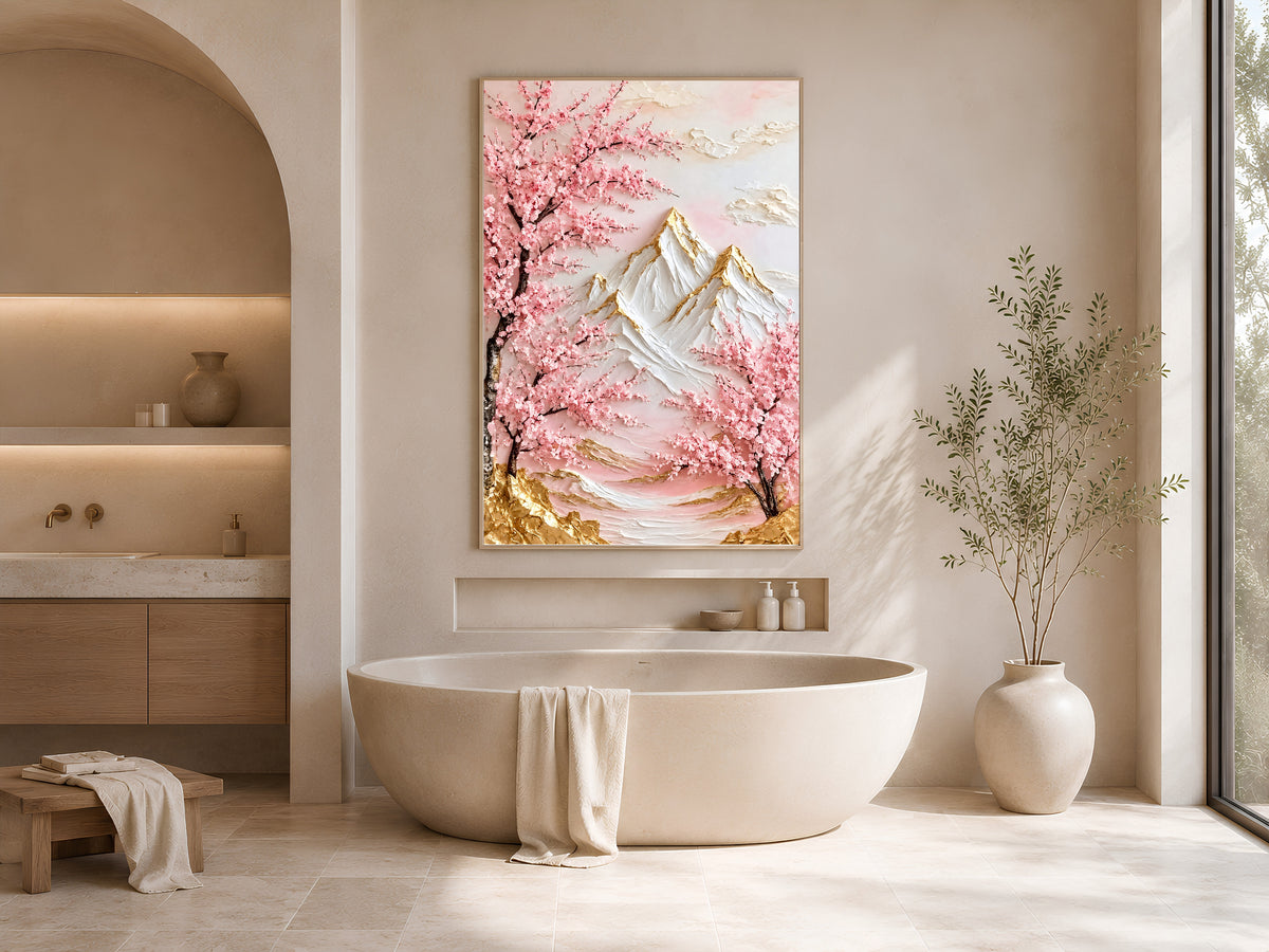 Cherry blossom mountain print in a gold frame above a freestanding oval bathtub in a warm-toned bathroom