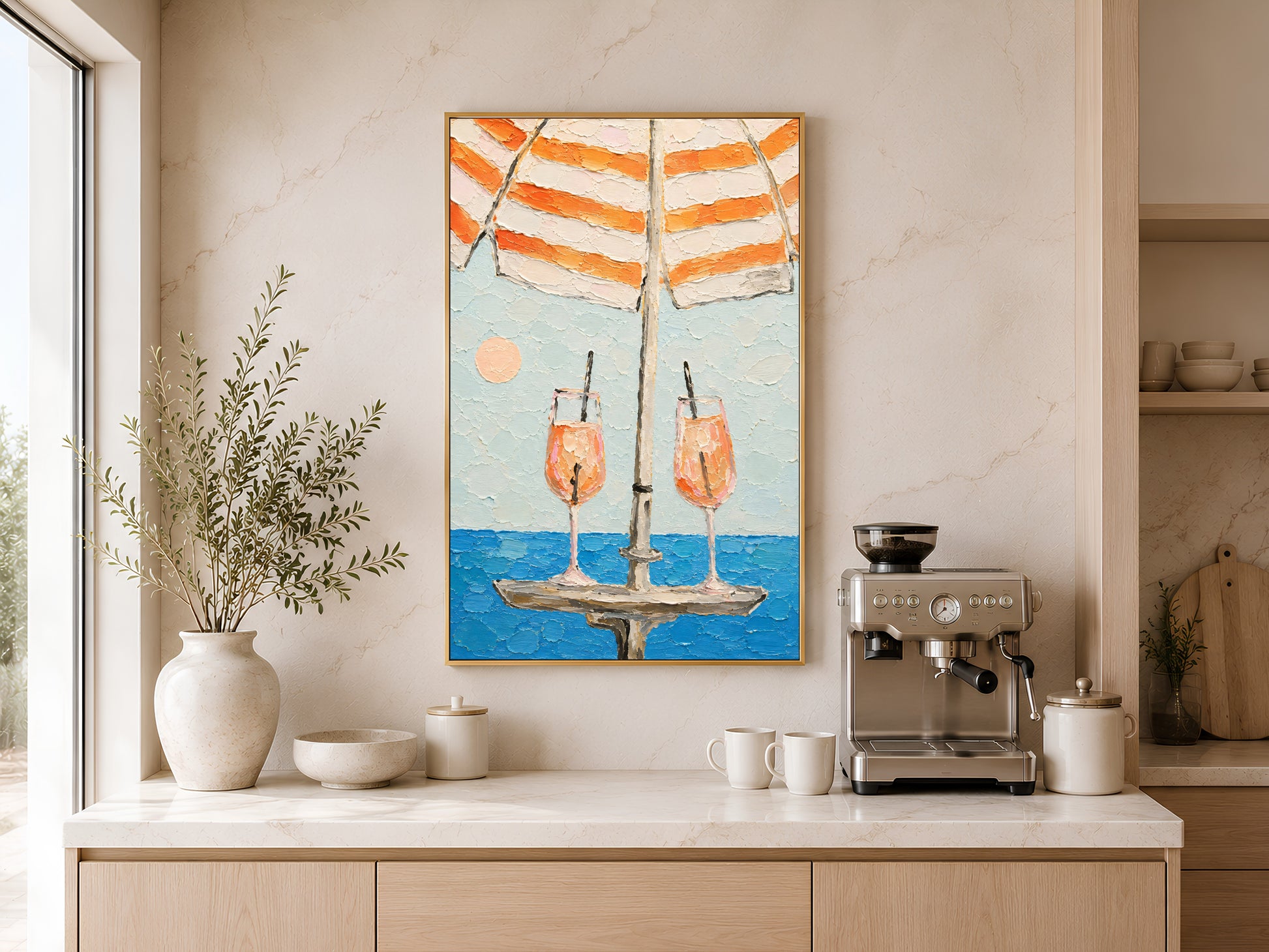 Framed aperol spritz cocktail impasto print hung above a wooden sideboard with ceramic bowls in a warm neutral kitchen with soft natural light
