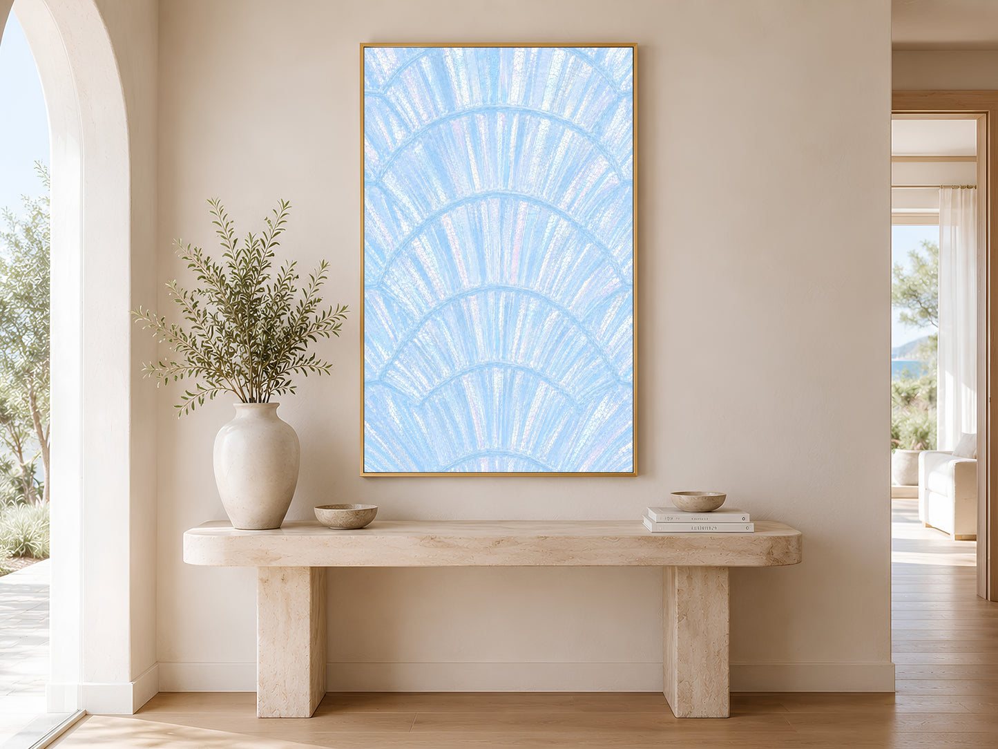 Iridescent blue shell wall art in gold frame above a console table in a minimal bright neutral hallway with ceramic vase