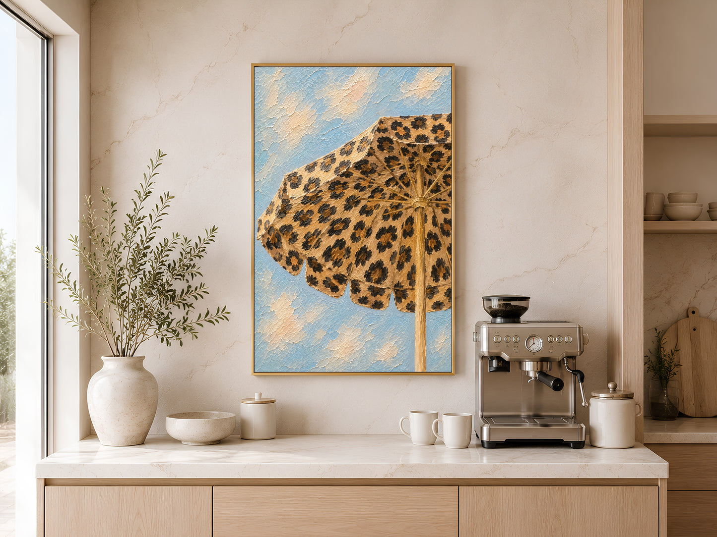 Framed leopard beach umbrella painting print on a warm white wall above a kitchen sideboard with ceramic vases and soft natural light
