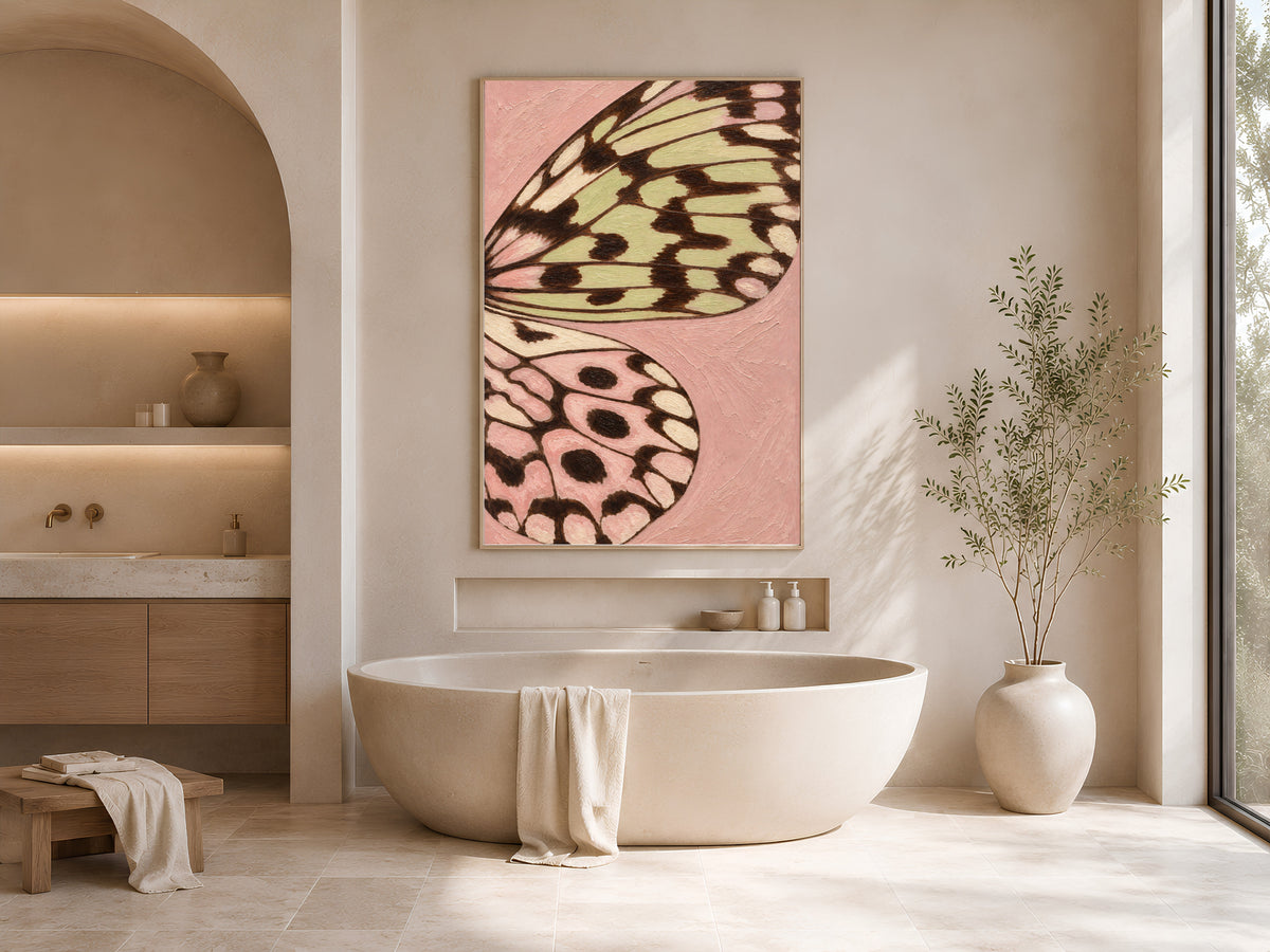 Butterfly wing art print framed above a freestanding bathtub in a neutral spa-style bathroom