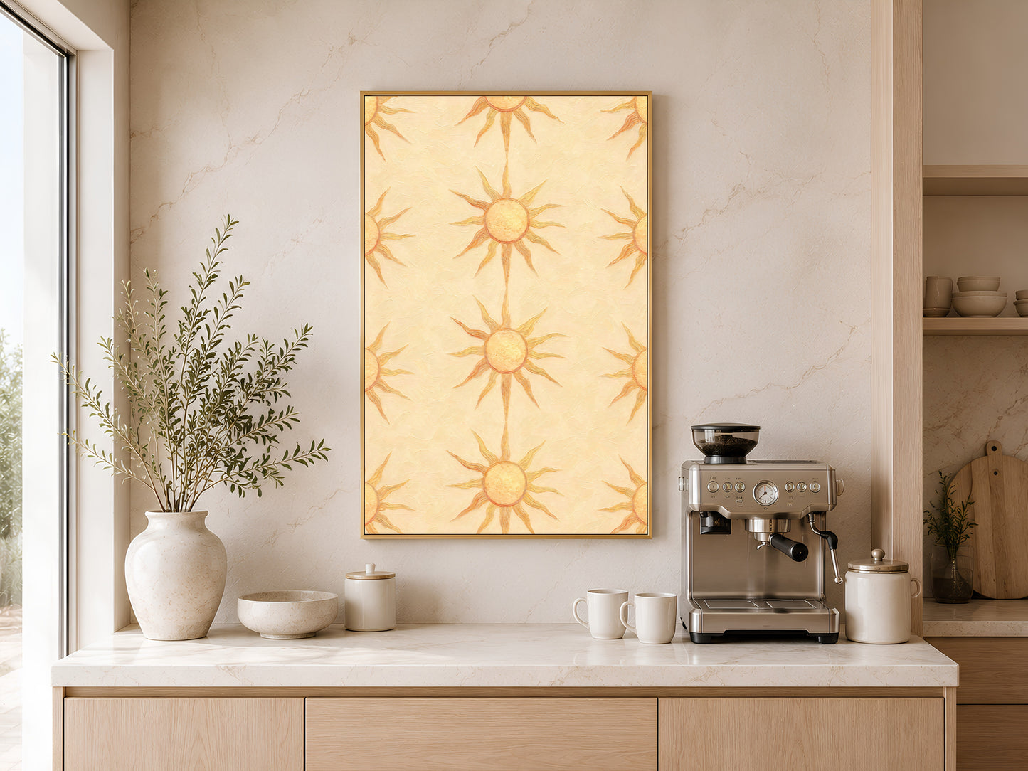 Boho sun wall art print framed above a kitchen counter with an espresso machine, ceramic vase, and warm wood cabinetry.
