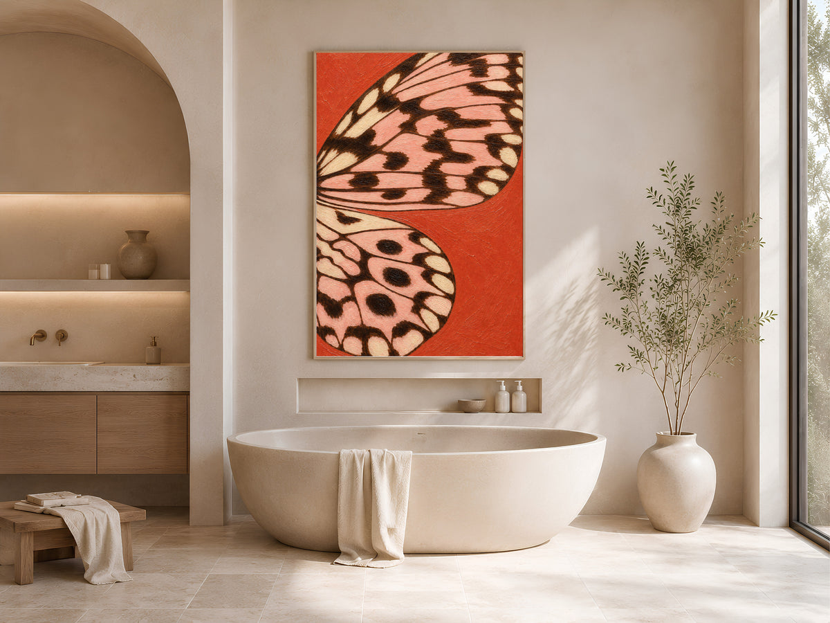 Tomato red butterfly wing print framed above a freestanding tub in a warm neutral bathroom