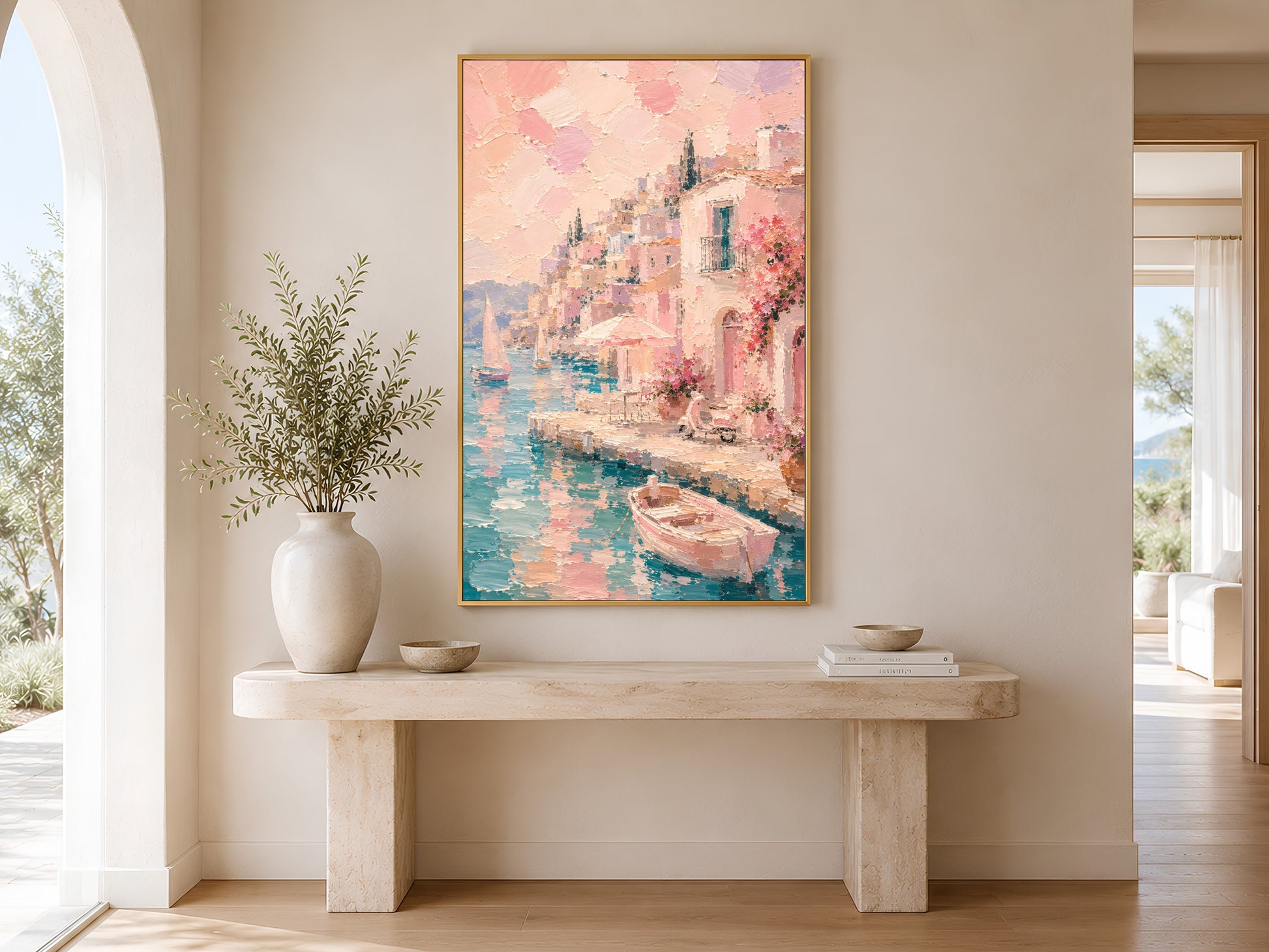 Pink Mediterranean art print in gold frame above a marble console table in a minimal bright neutral hallway