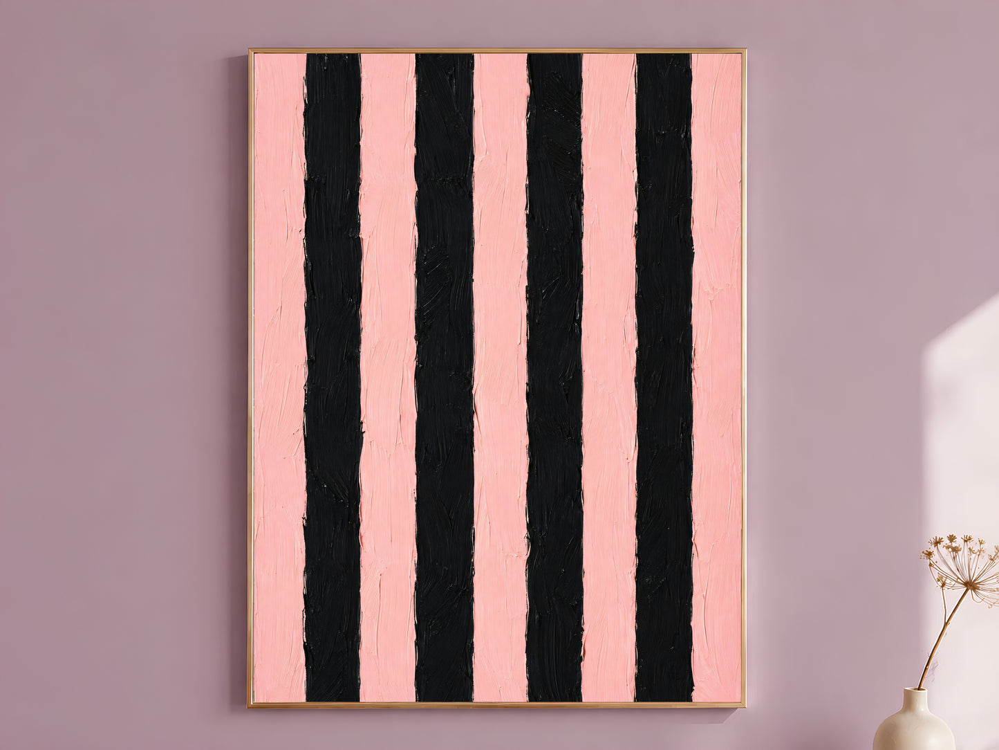 Bold pink and black stripe impasto wall art in gold frame on mauve wall with dried flower stems
